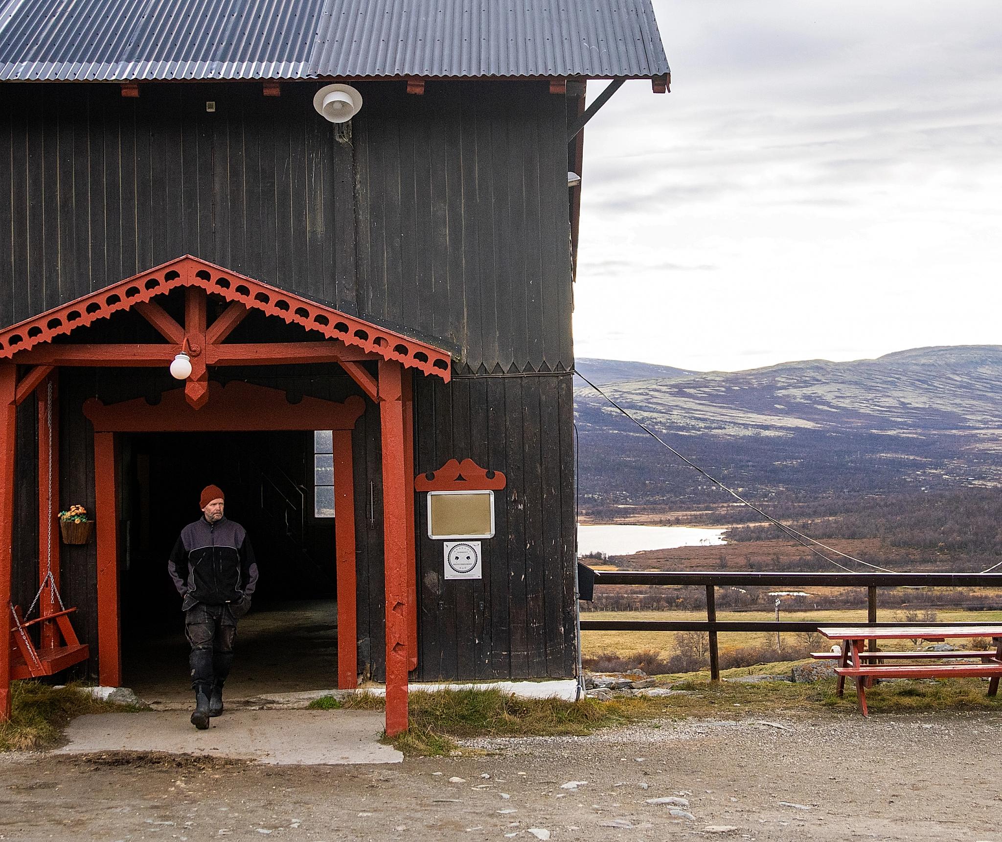 The stable at Hjerkinn Fjellstue, mountain lodge, with mountains in the background.