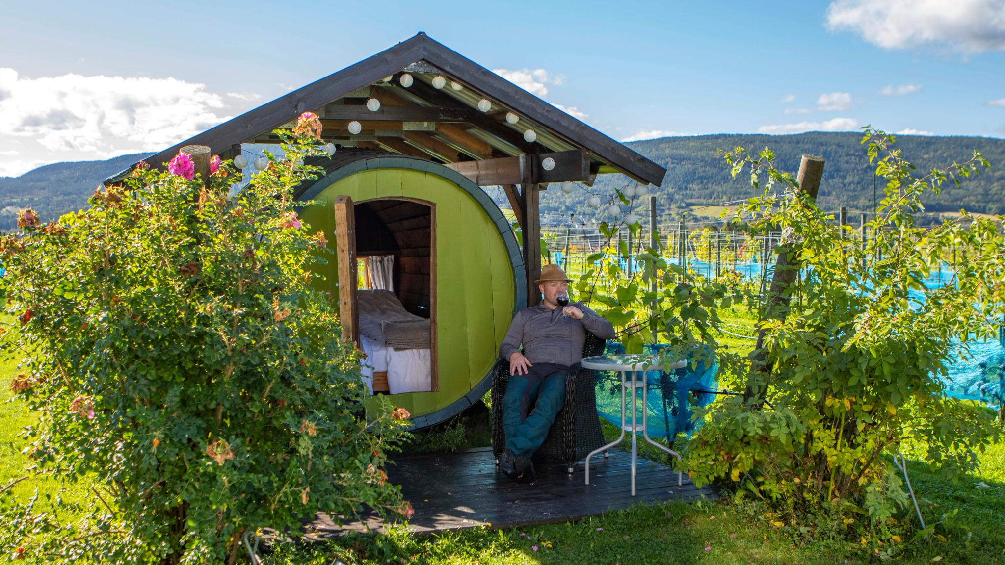 A man sitting outside of a wine barrel at the Lerkekåsa farm