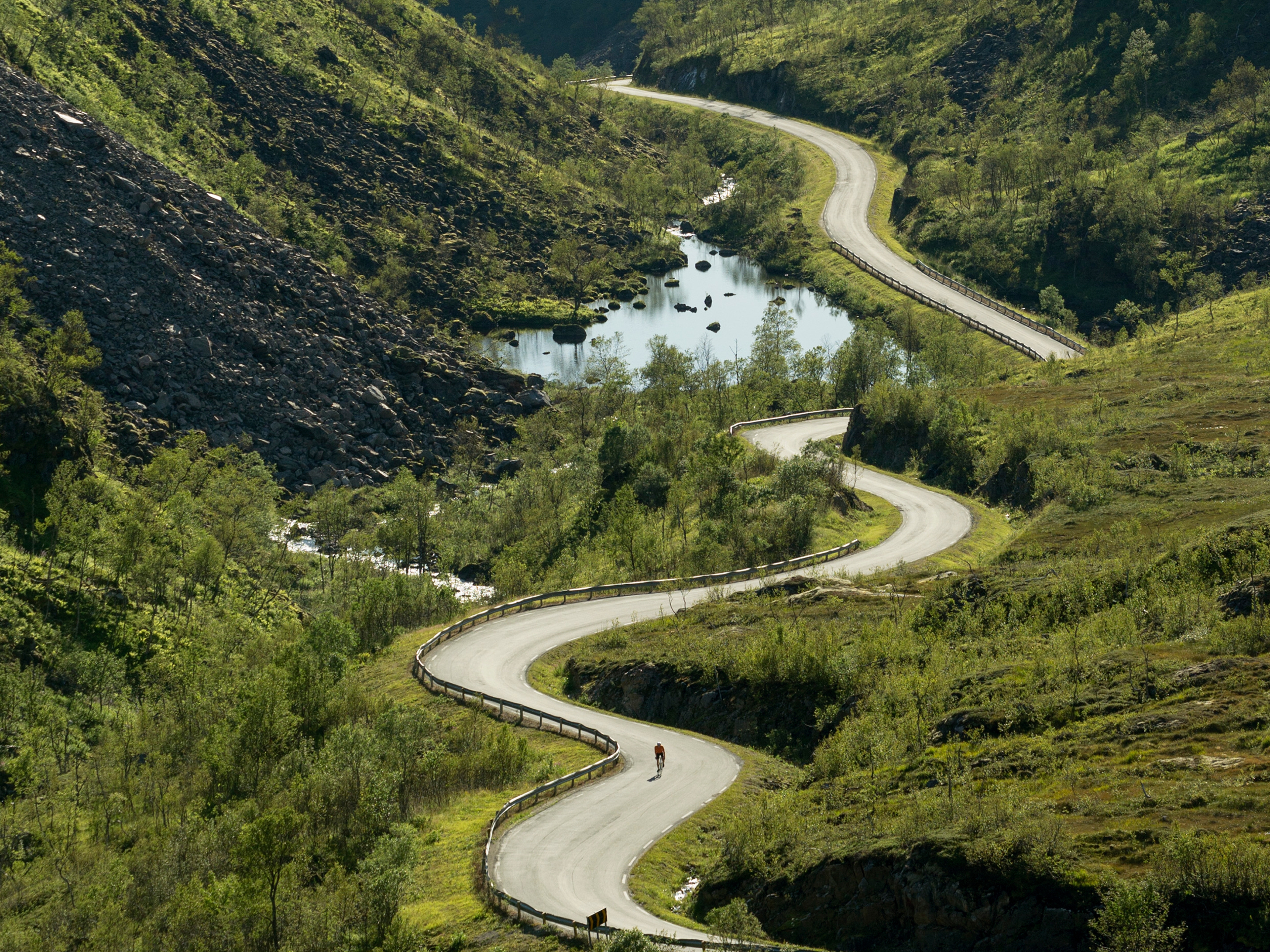 En landeveissyklist på vei gjennom Kaperskaret på Senja i Nord-Norge