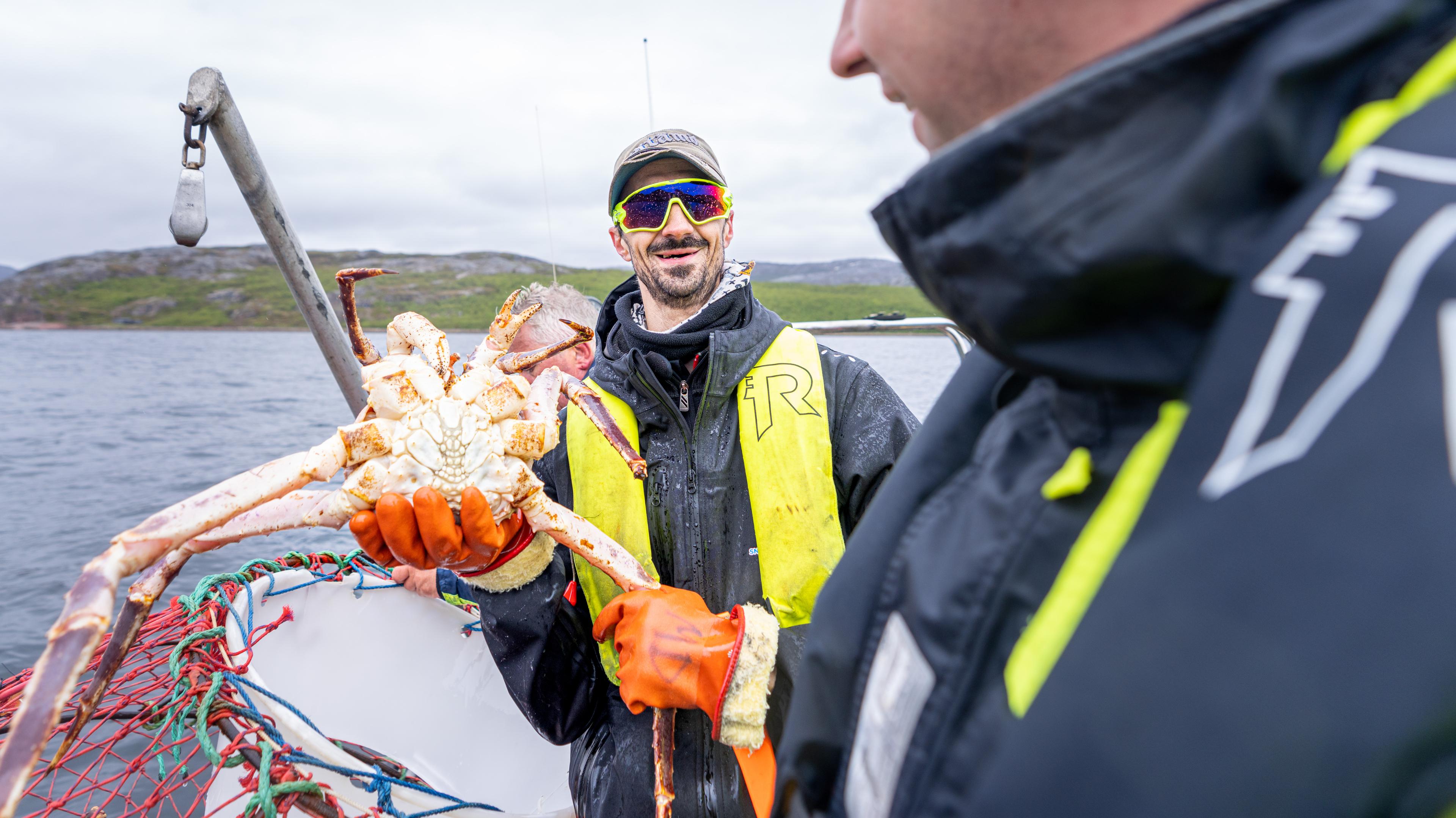 Guide Michael Decker from Snowhotel Kirkenes holding a king crab, Northern Norway