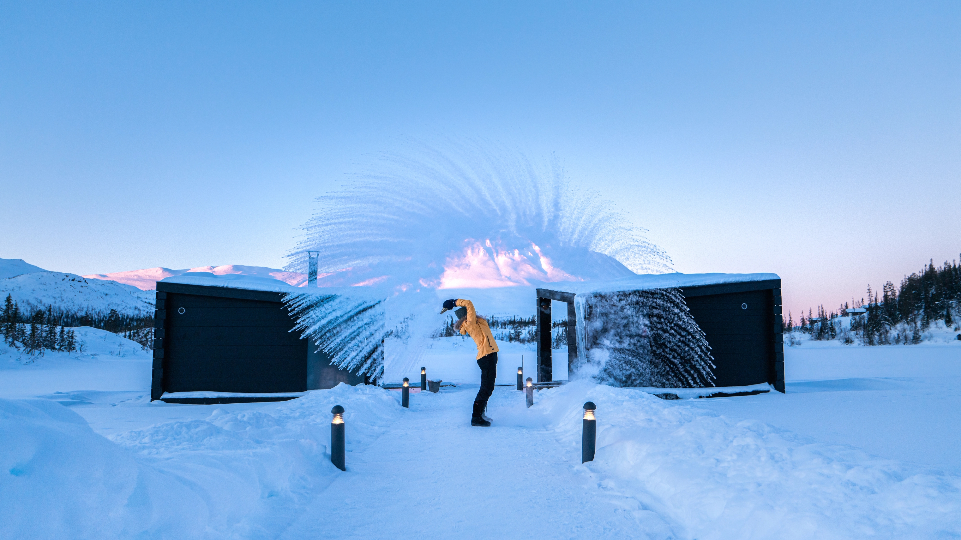 Girl throwing snow in front of the floating saunas at Gausta in winter, Telemark