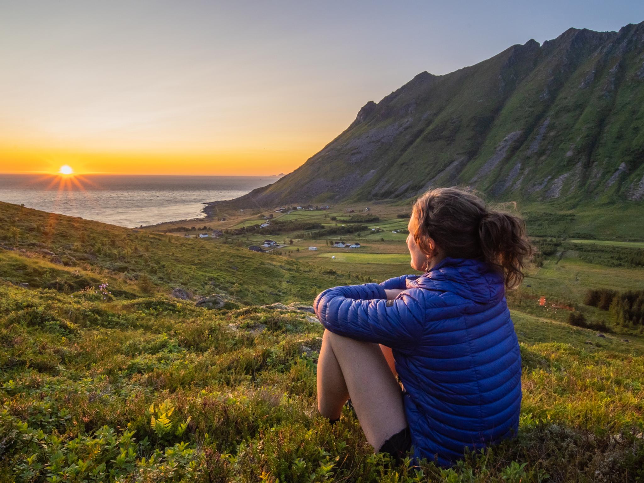 Woman looking at the midnightsun in Lofoten, Northern Norway
