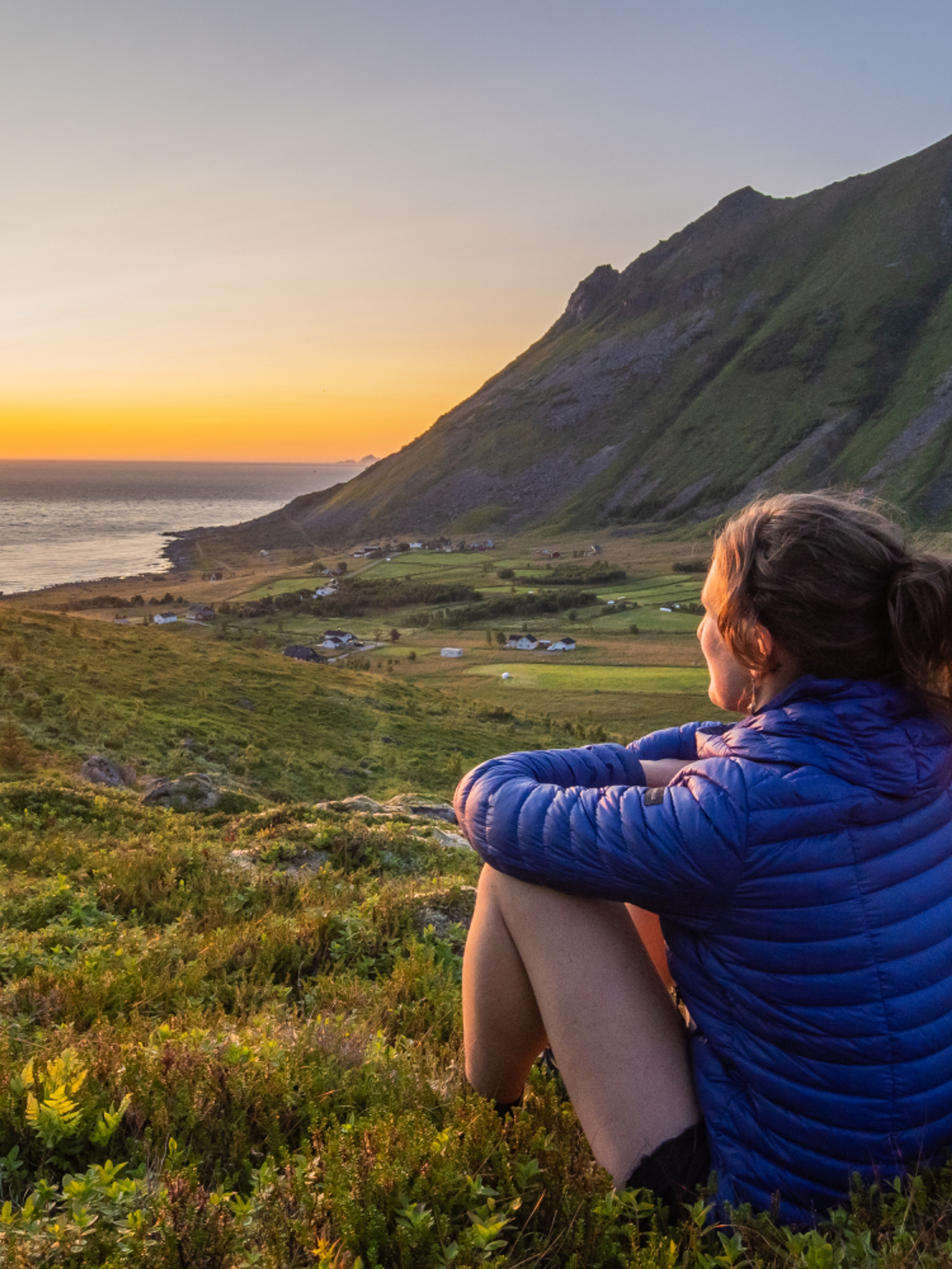 Woman looking at the midnightsun in Lofoten, Northern Norway
