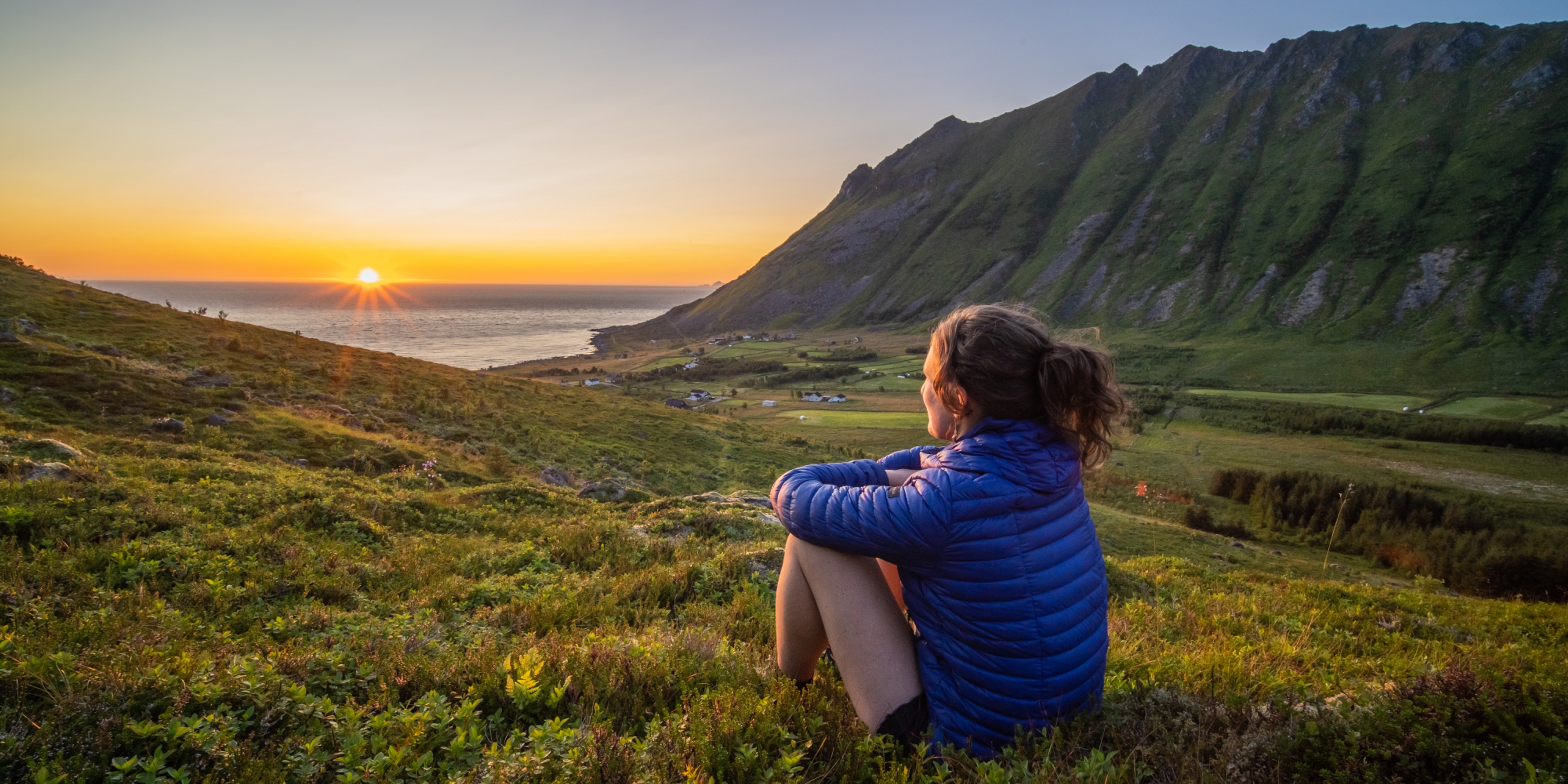 Woman looking at the midnightsun in Lofoten, Northern Norway