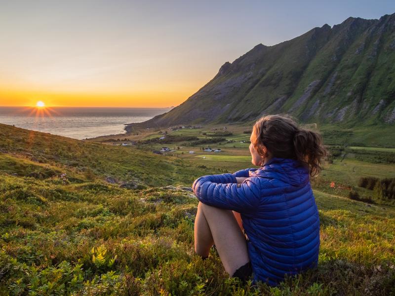 Woman looking at the midnightsun in Lofoten, Northern Norway