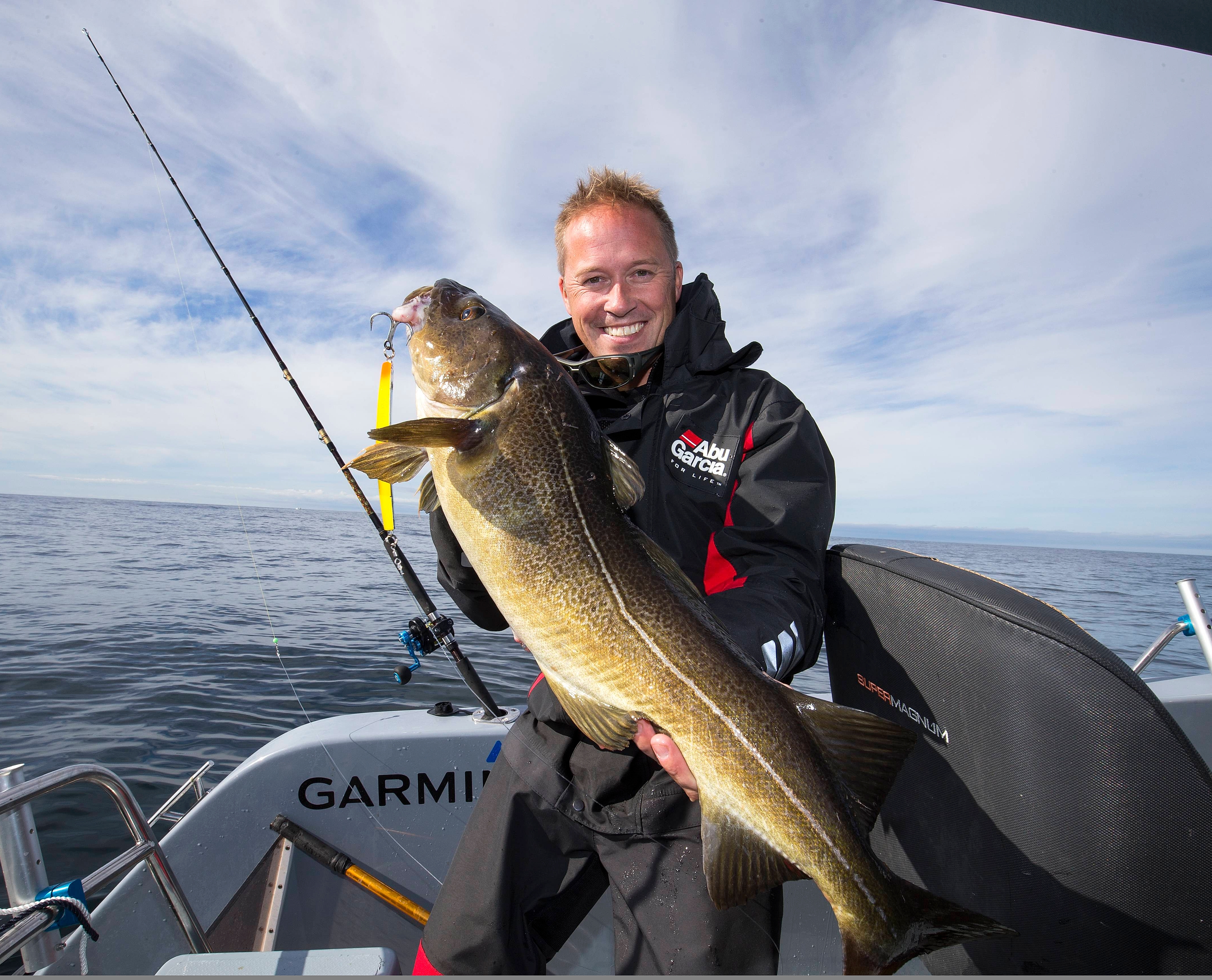 A man showing his big catch from a boat at sea
