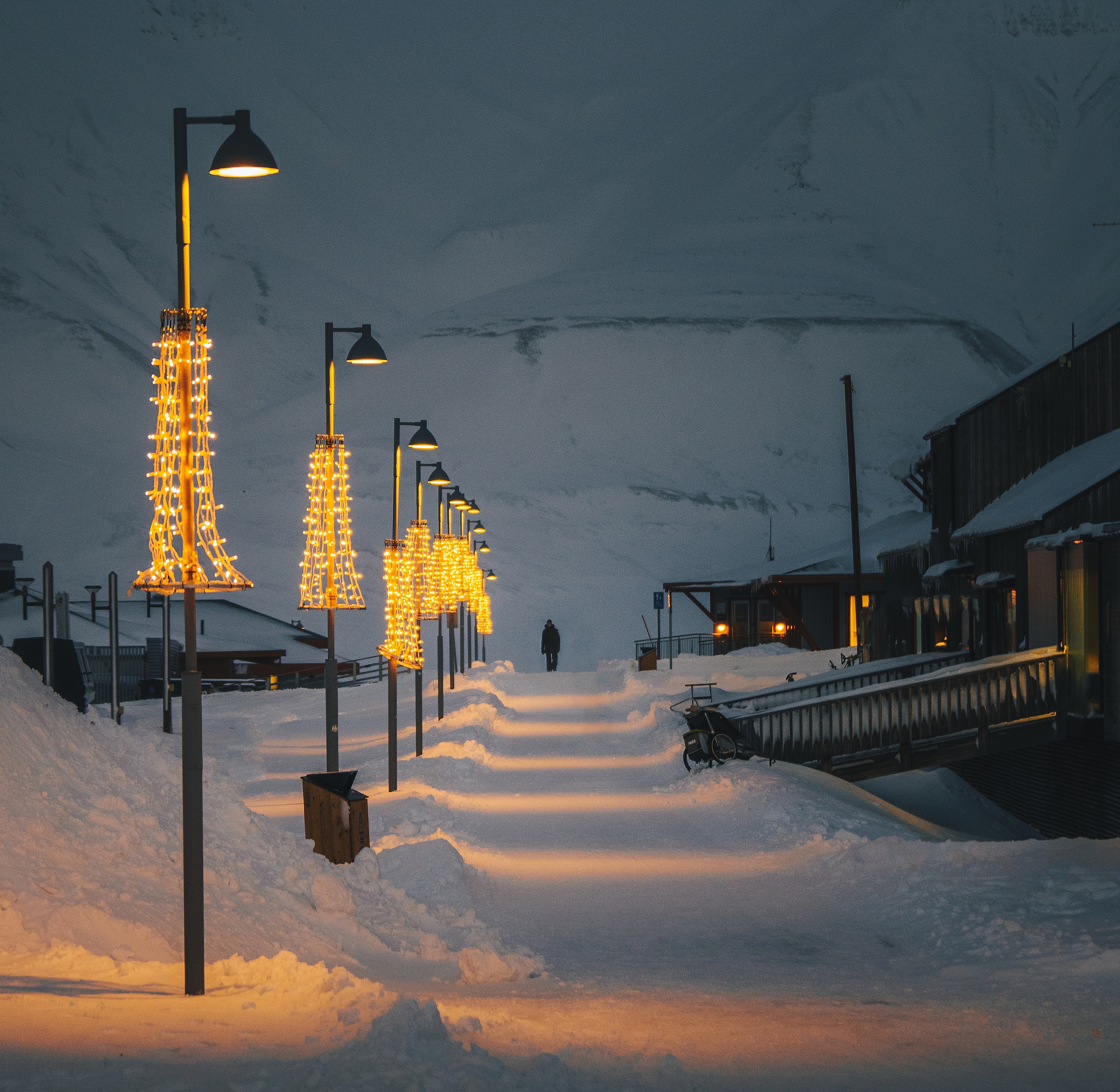 A person walking along Longyearbyen walkway during polar night