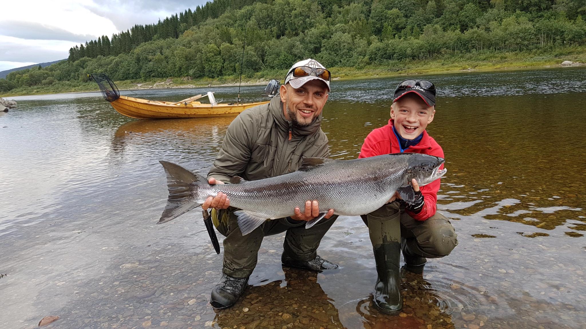 Father and son hold up a big salmon they caught in the Namsen river in Namdalen, Trøndelag