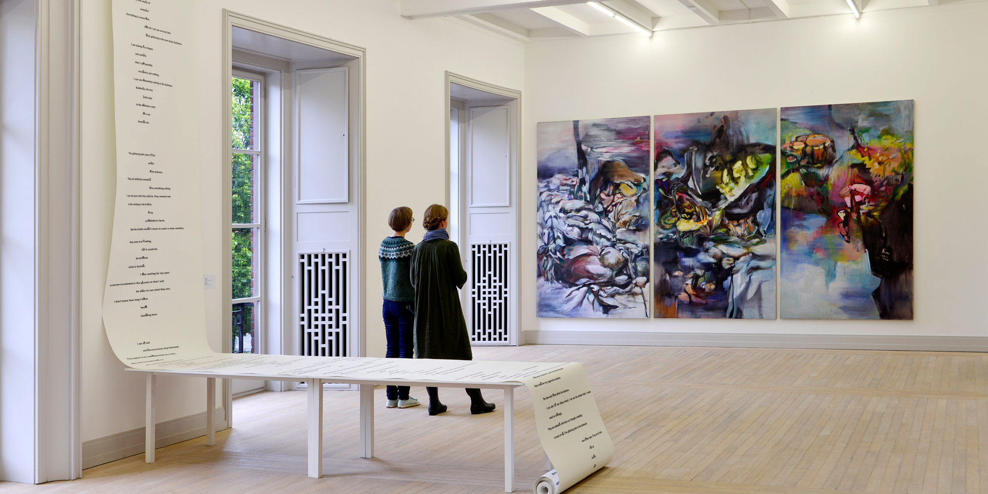 Två kvinnor tittar på en målning på Trondheim Kunstmuseum i regionen Trøndelag