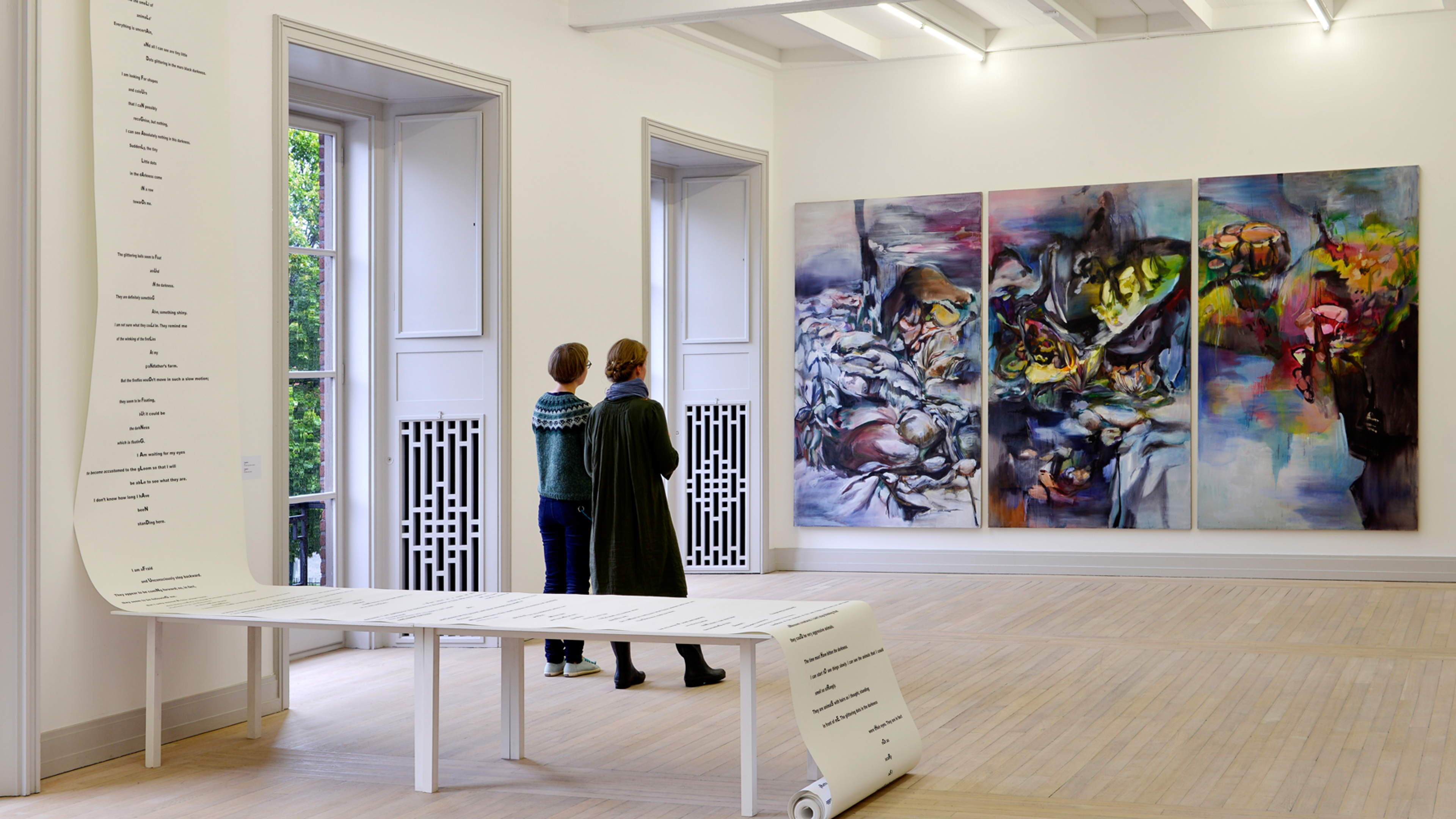 To damer står og ser på et maleri på Trondheim Kunstmuseum (Kunstmuseum) i Trøndelag