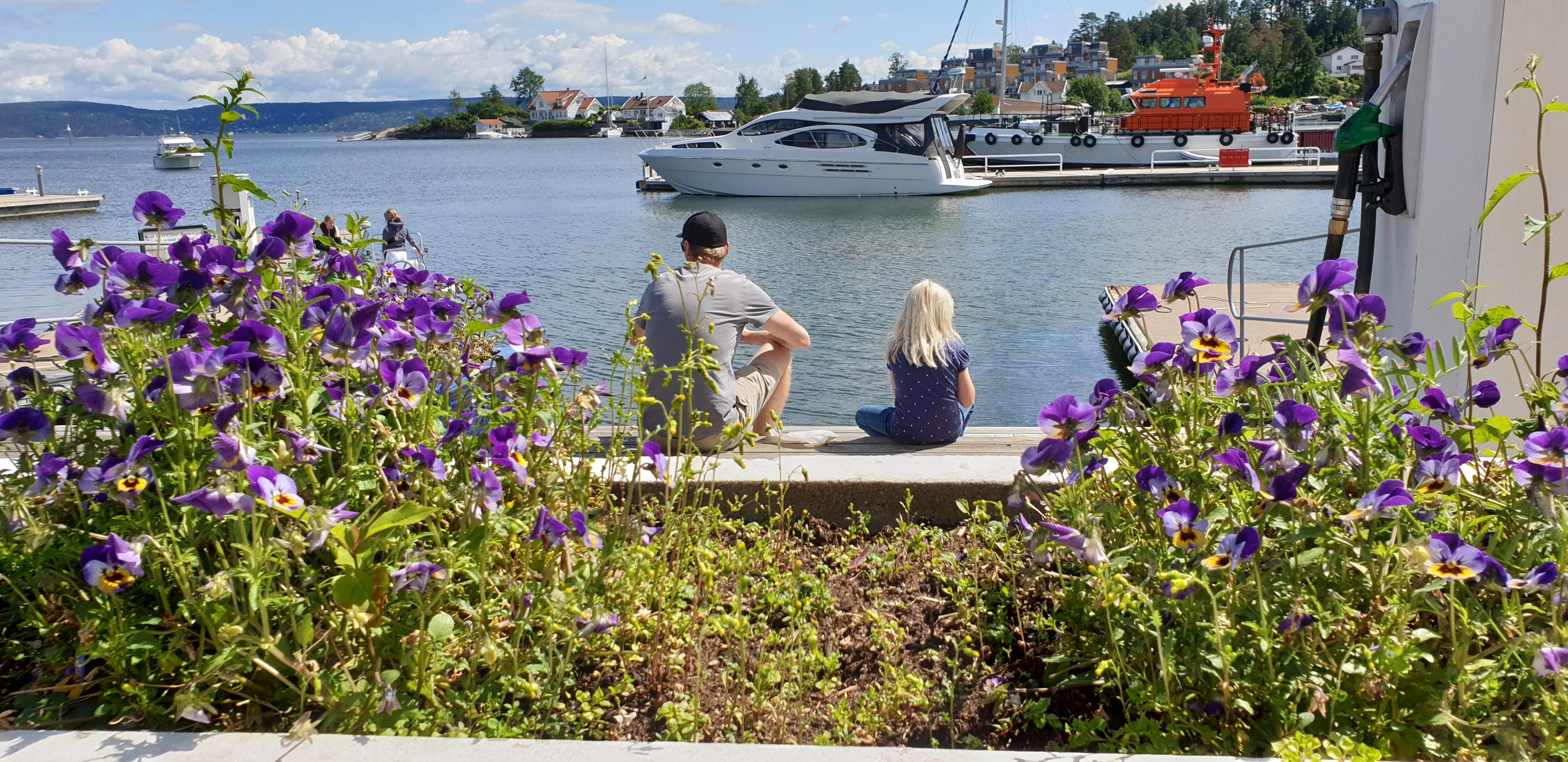 Father and daughter sitting by the marina in Vollen in Asker in the Oslo Region, Eastern Norway