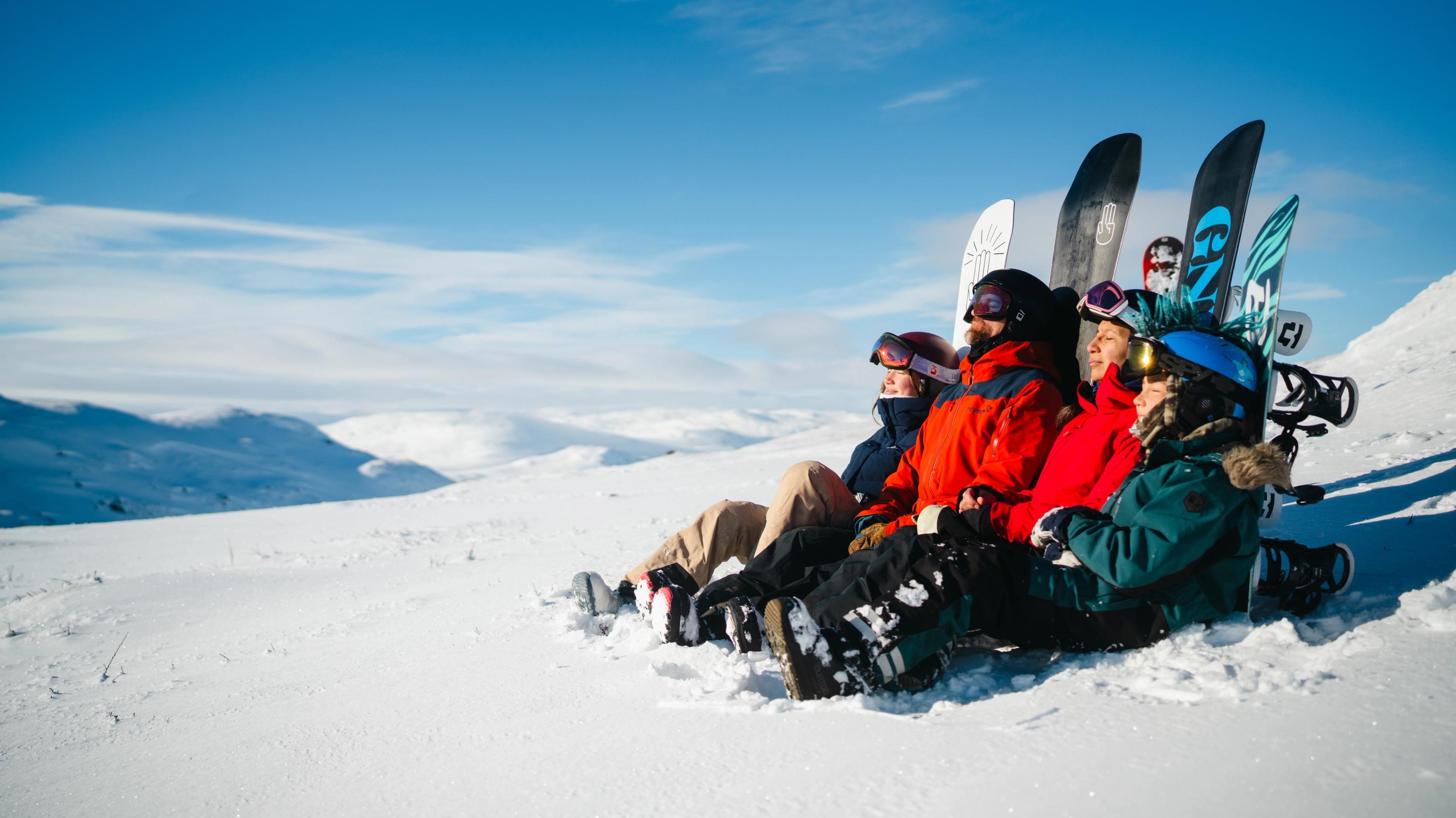 A family enjoying the sun after snowboarding