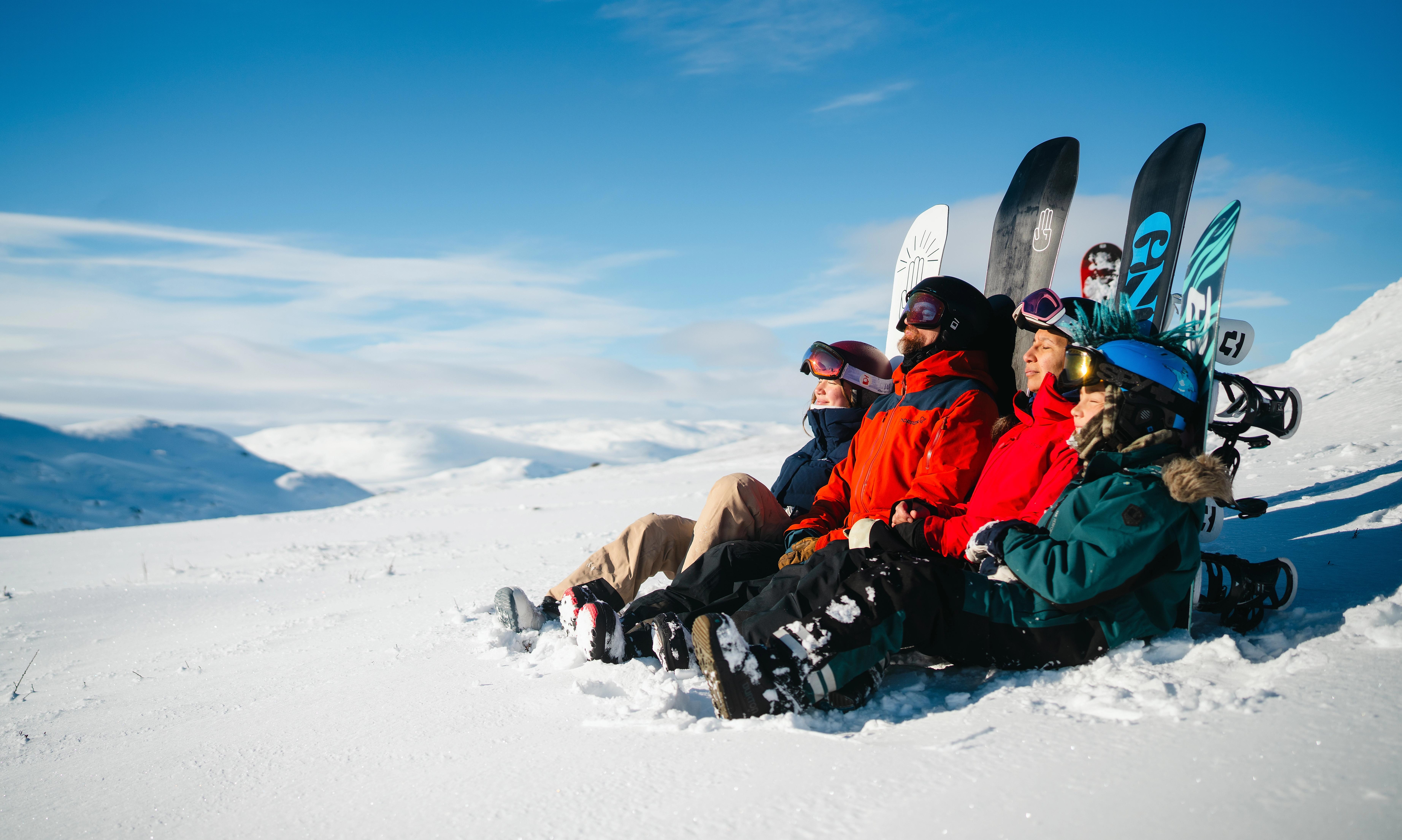 A family enjoying the sun after snowboarding
