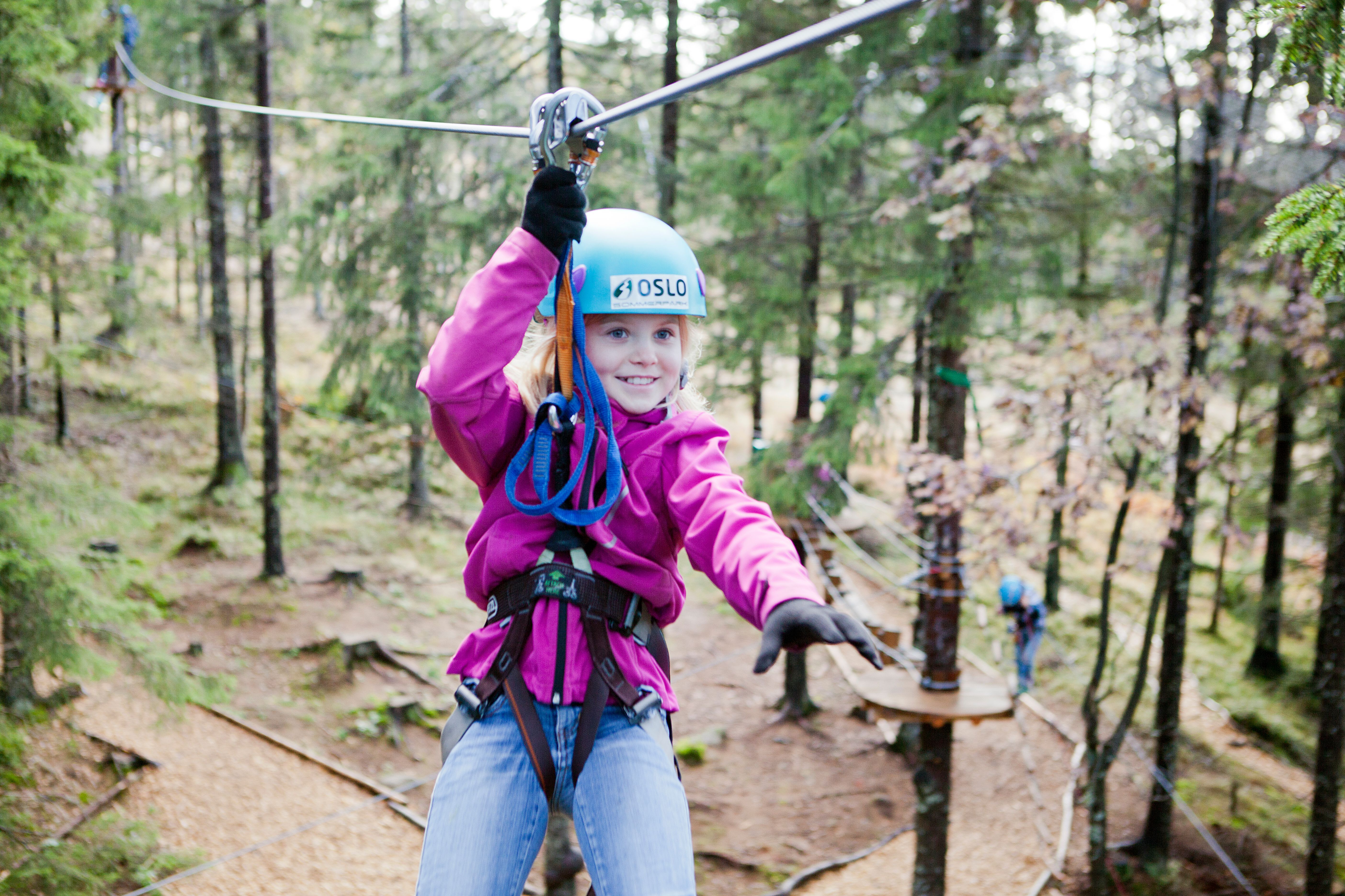 Een meisje aan de zipline in Oslo Sommerpark, Noorwegen