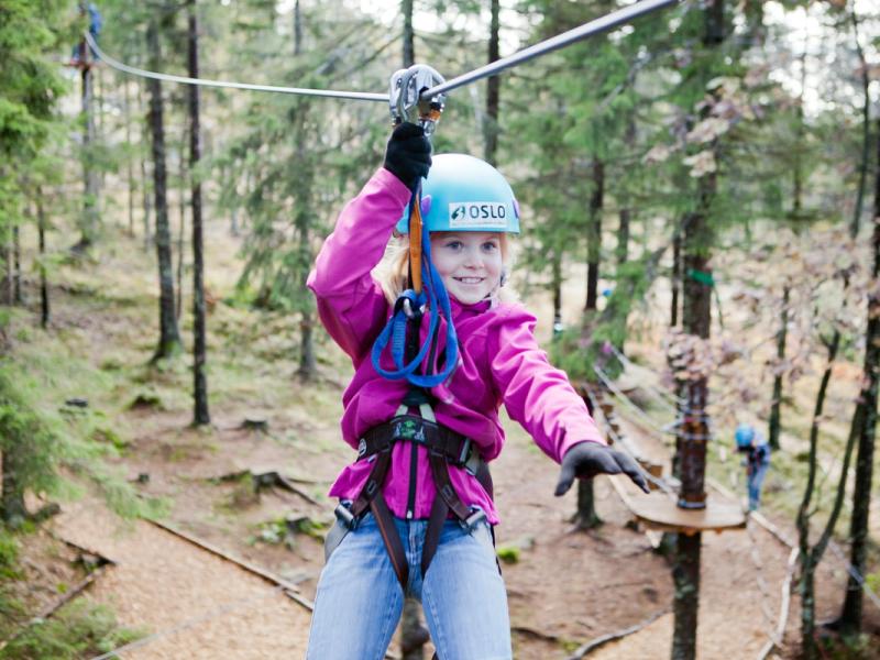 Een meisje aan de zipline in Oslo Sommerpark, Noorwegen