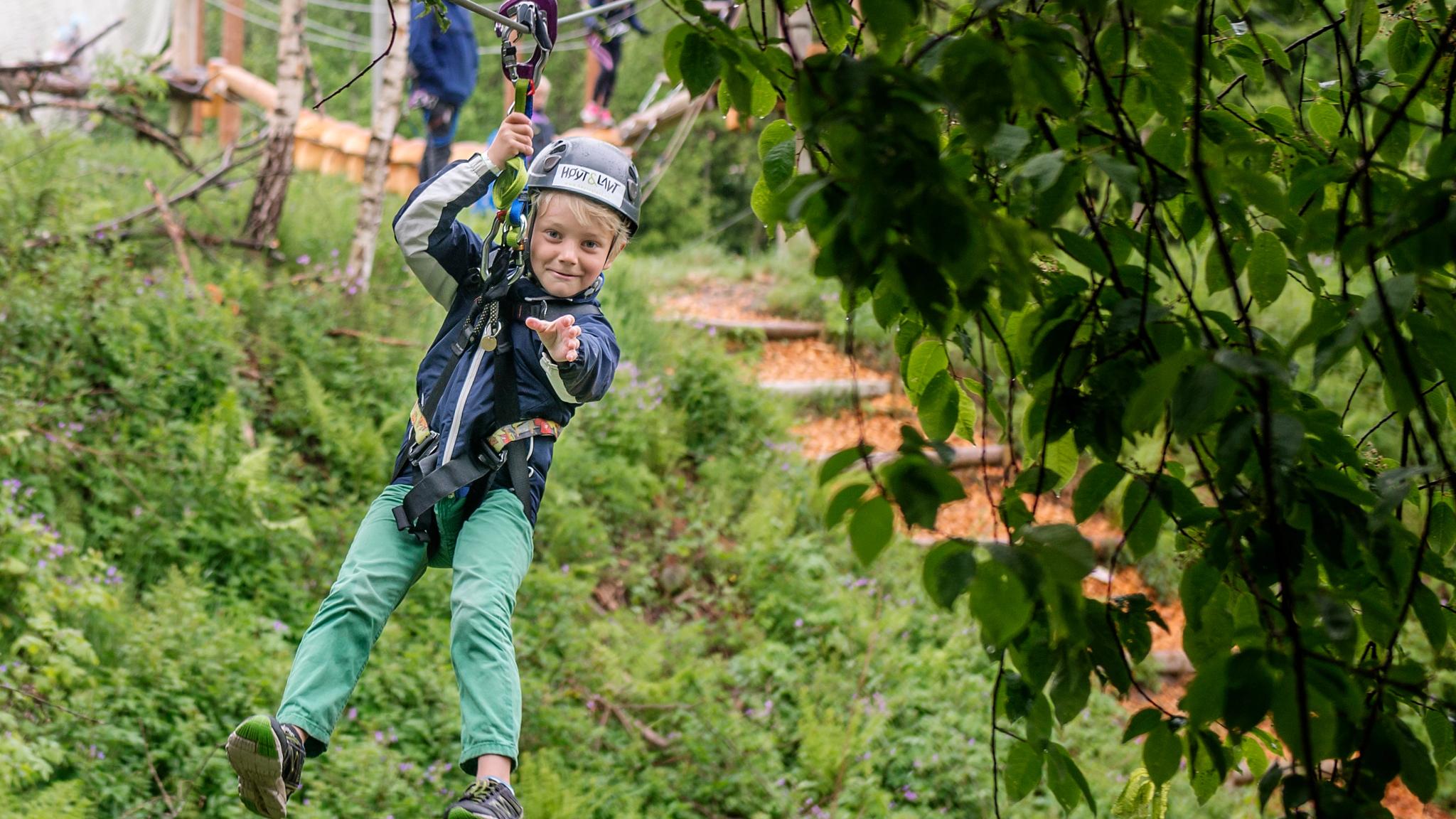 Pojke som åker zipline i parken Høyt & Lavt i Vestfold