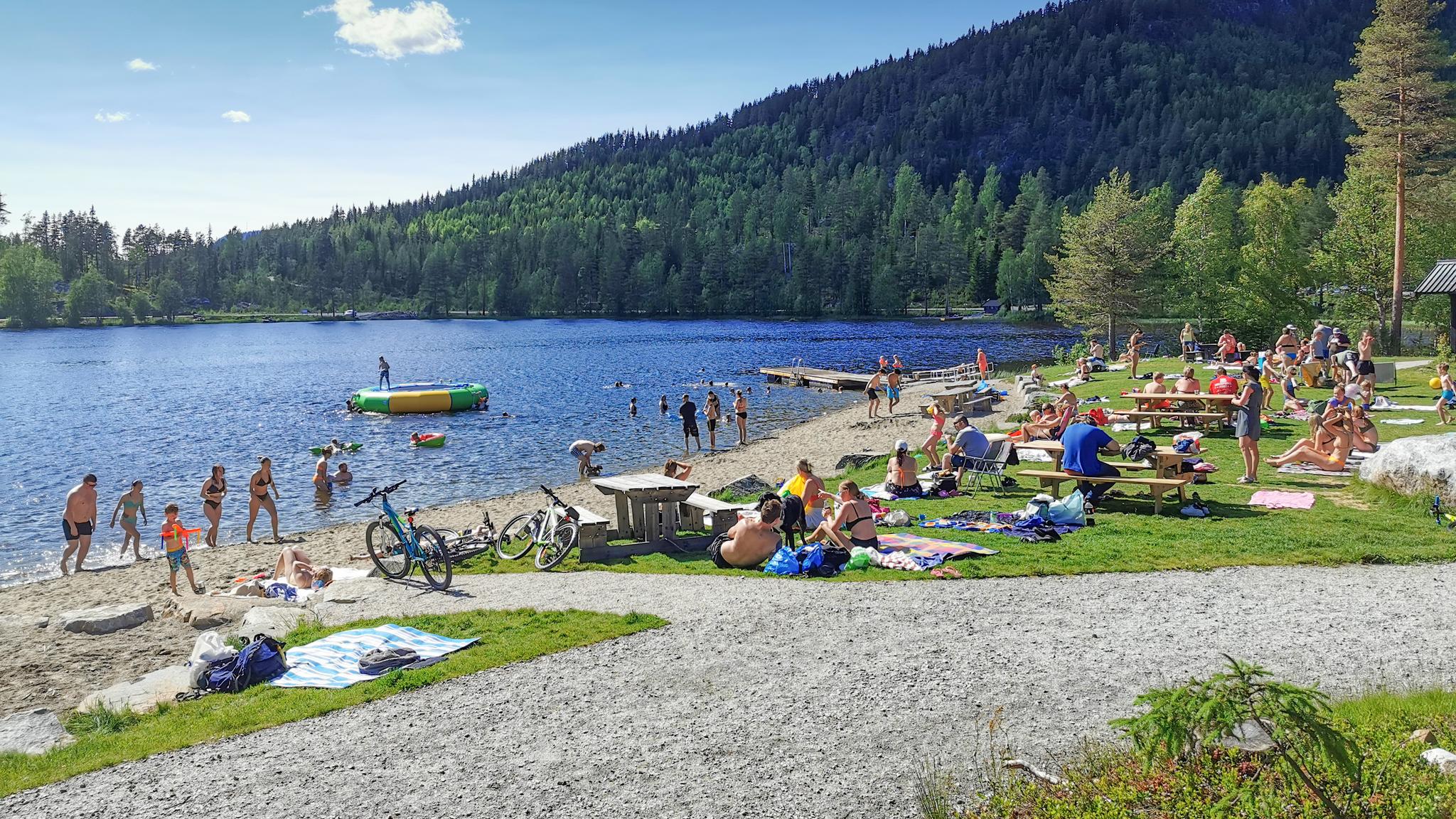 People swimming and sunbathing at Trytjern, Eastern Norway.