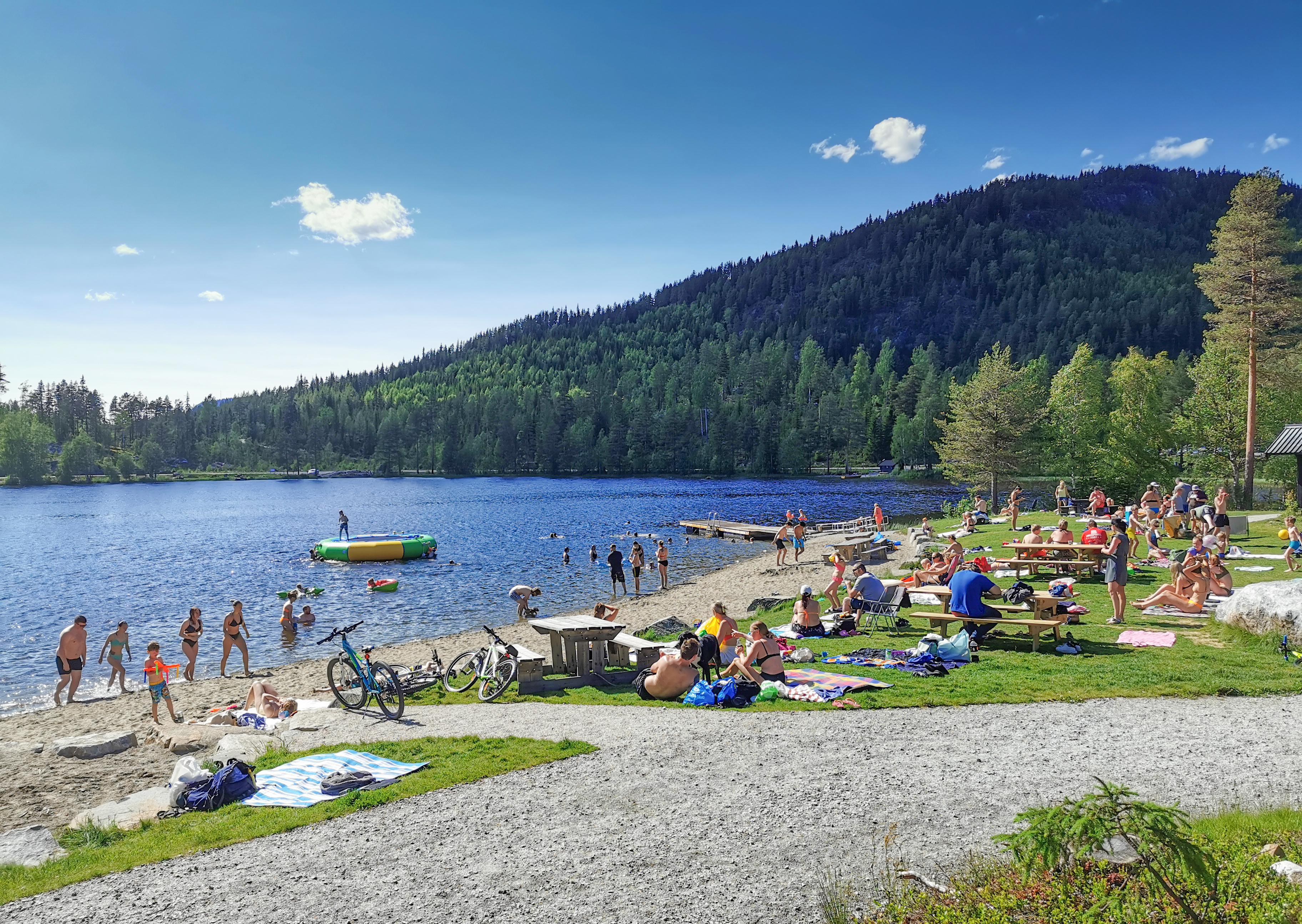 People swimming and sunbathing at Trytjern, Eastern Norway.