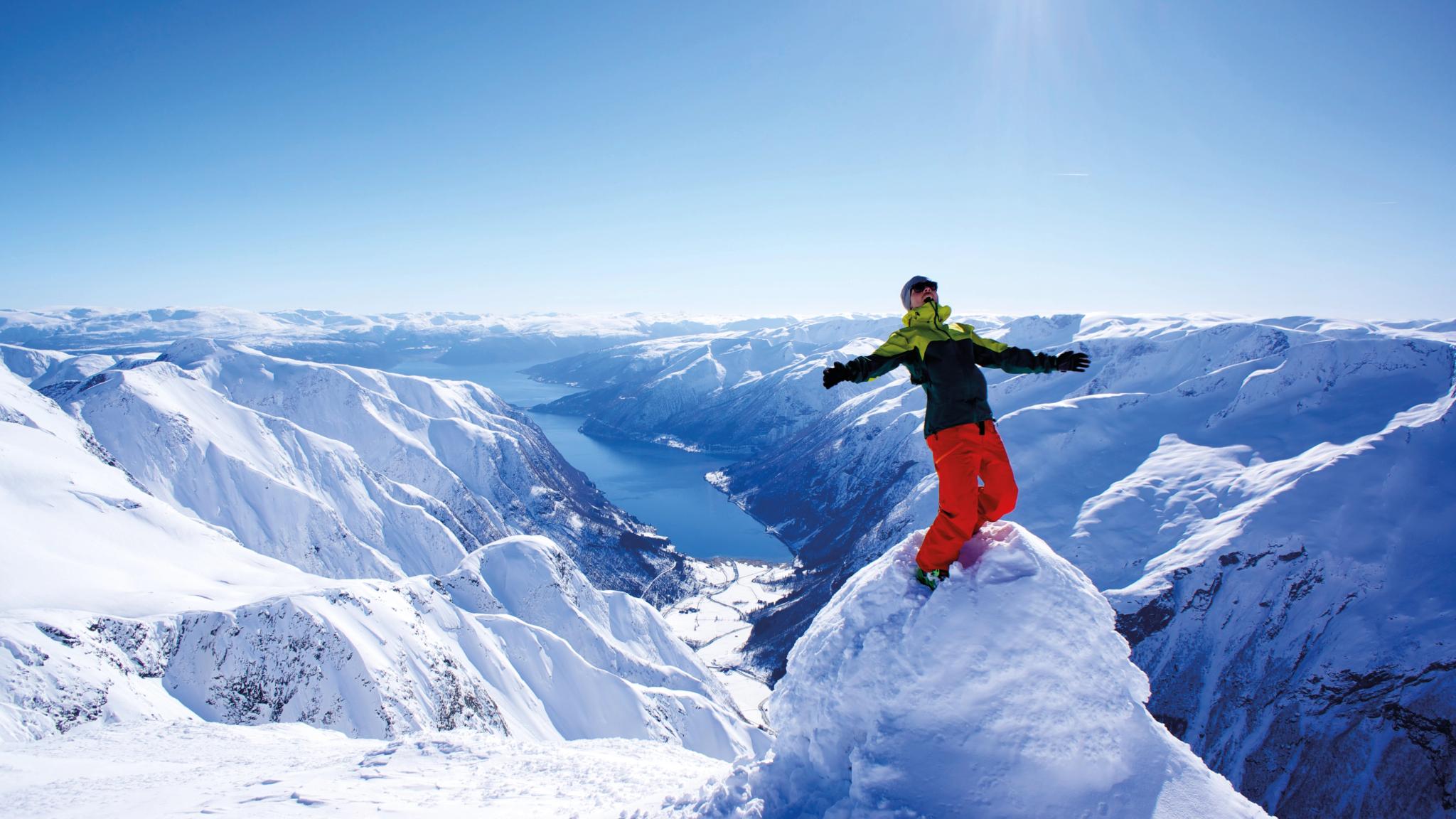 A person is standing on top of the Melsnipa peak in Fjærland in Fjord Norway