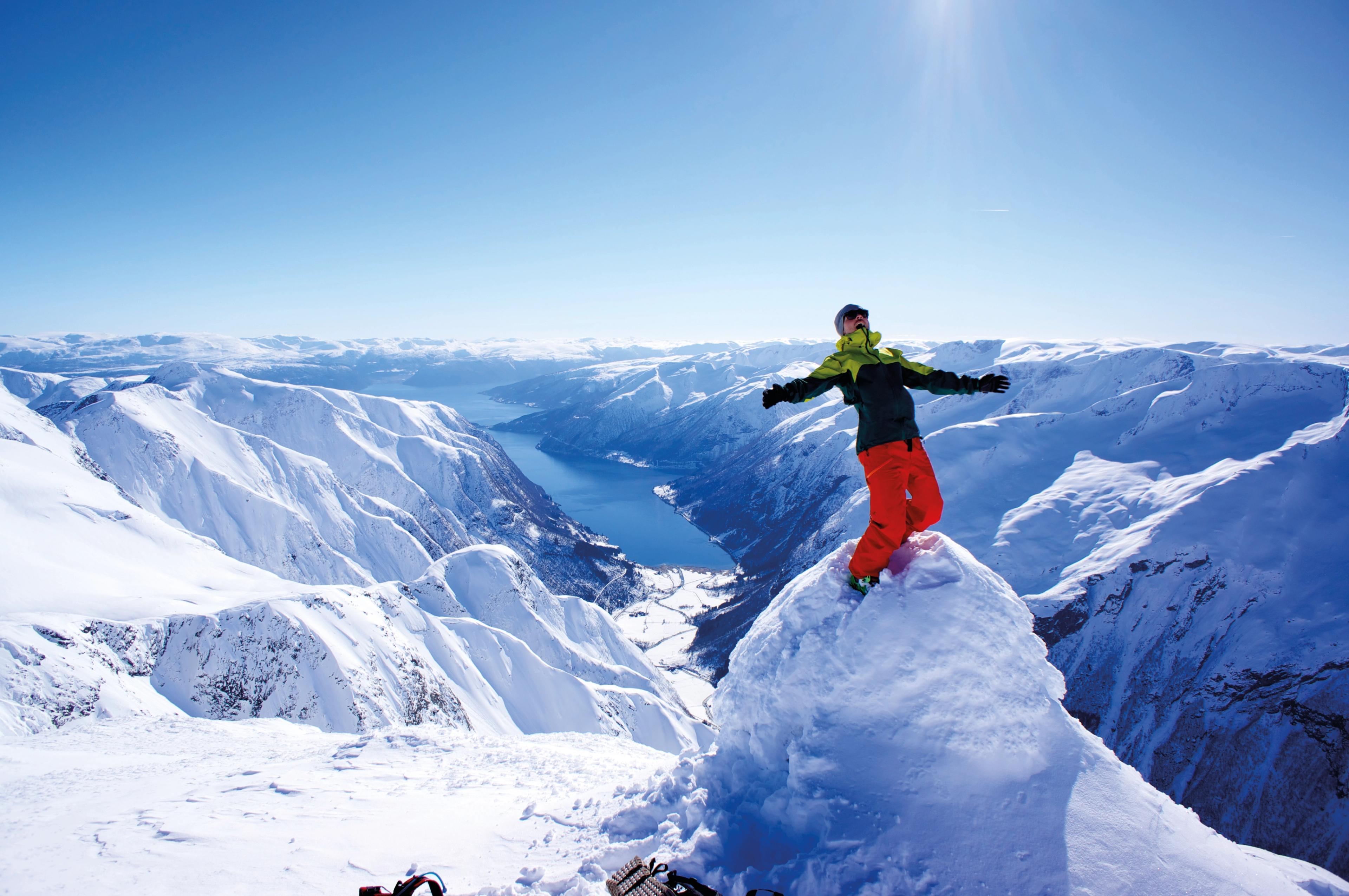 A person is standing on top of the Melsnipa peak in Fjærland in Fjord Norway