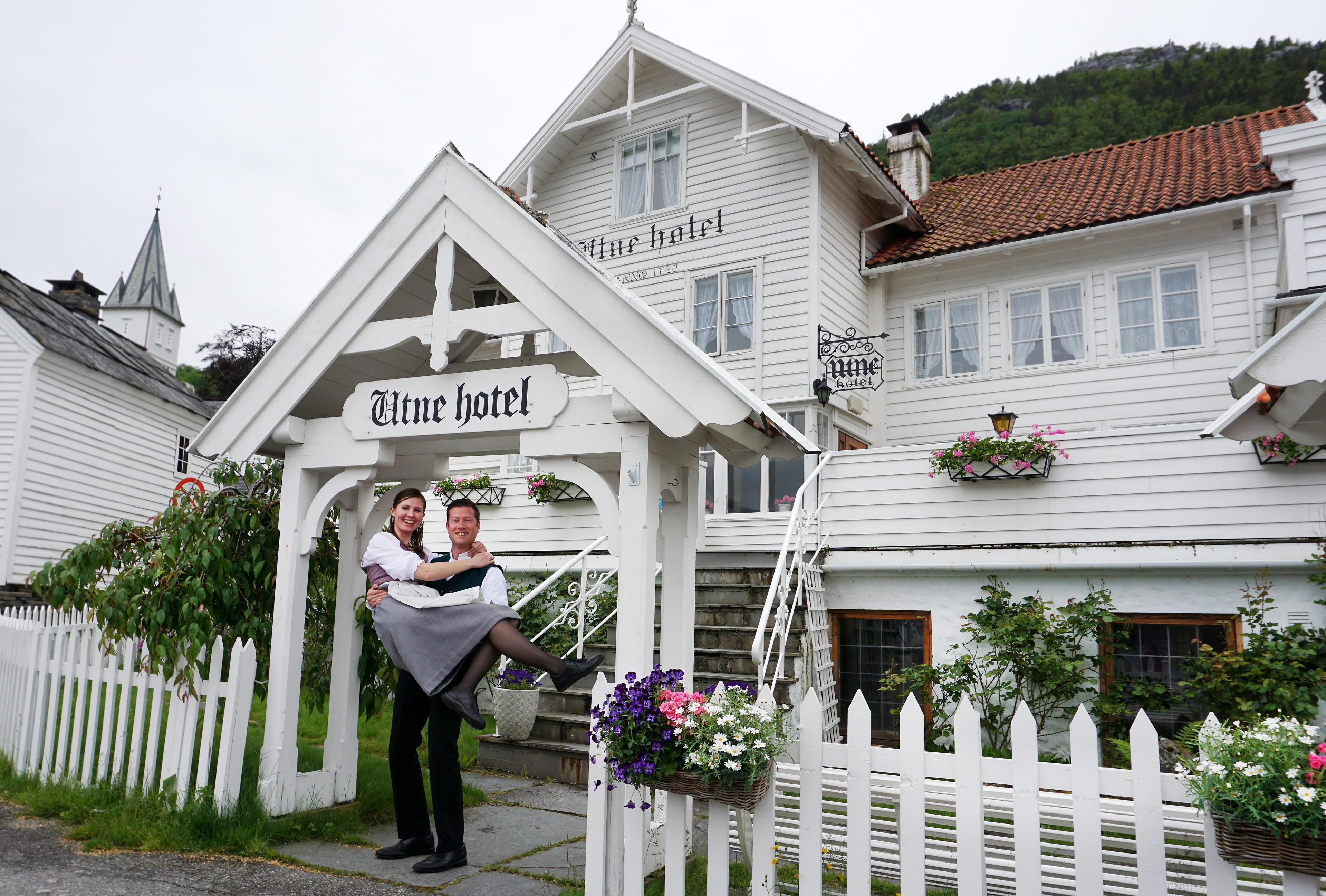 Bente R. och Kjetil Wedding, Utne Hotells ägare, står utanför hotellet i Hardangerfjord i regionen Fjord Norge (Vestlandet)