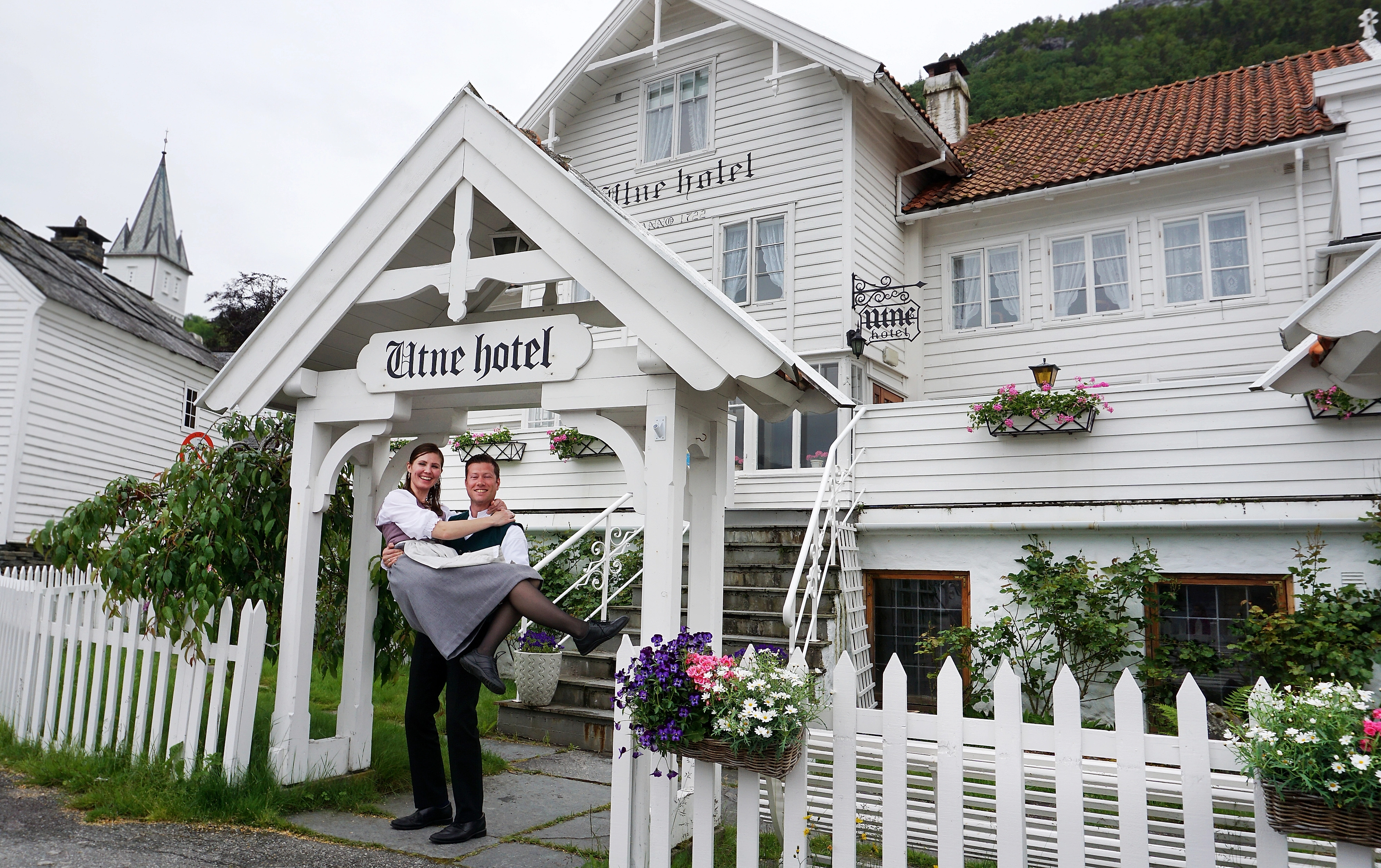 Bente R. og Kjetil Widding, eierne av Utne Hotel, står utenfor hotellet i Hardanger på Vestlandet