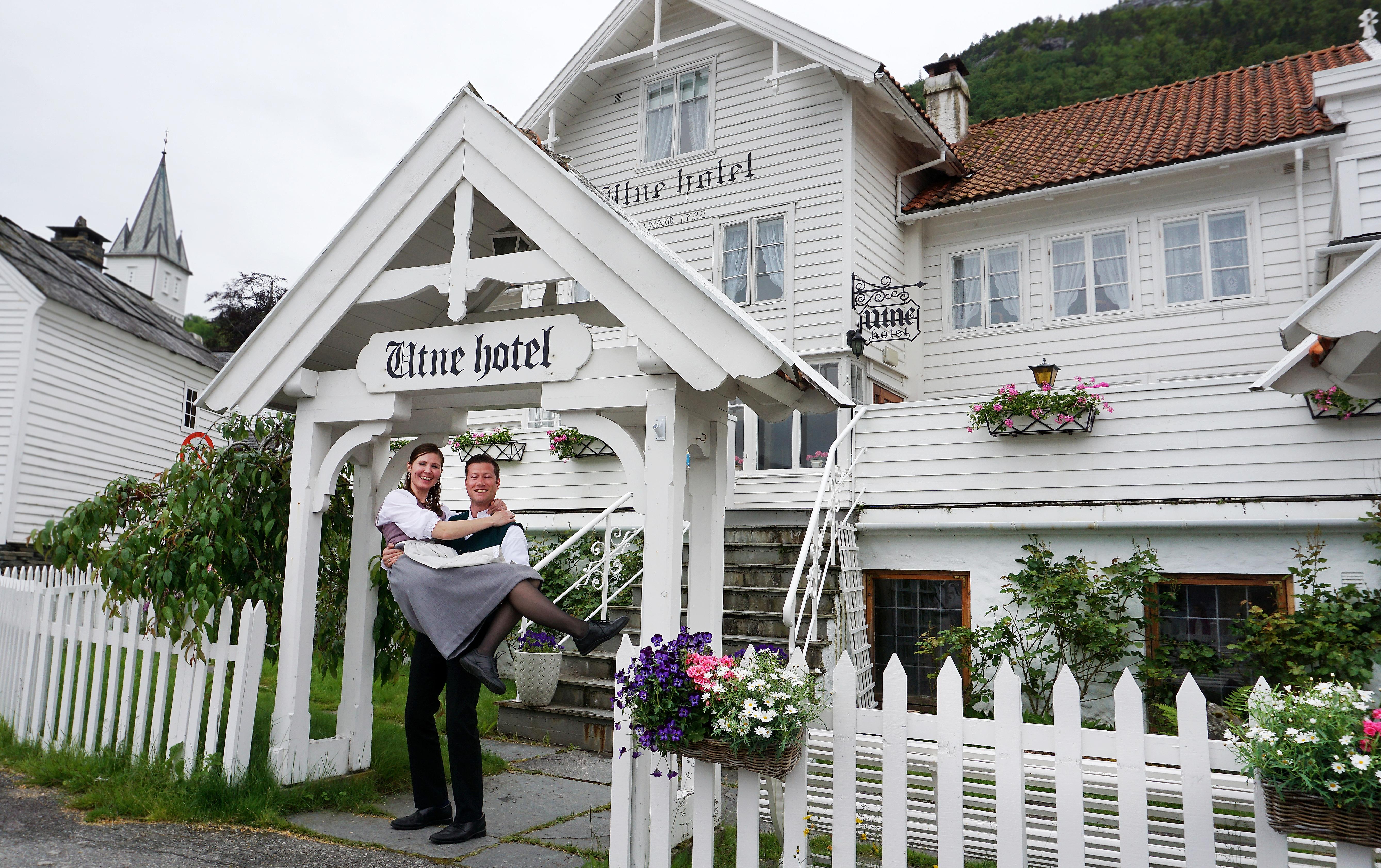 Bente R. och Kjetil Wedding, Utne Hotells ägare, står utanför hotellet i Hardangerfjord i regionen Fjord Norge (Vestlandet)