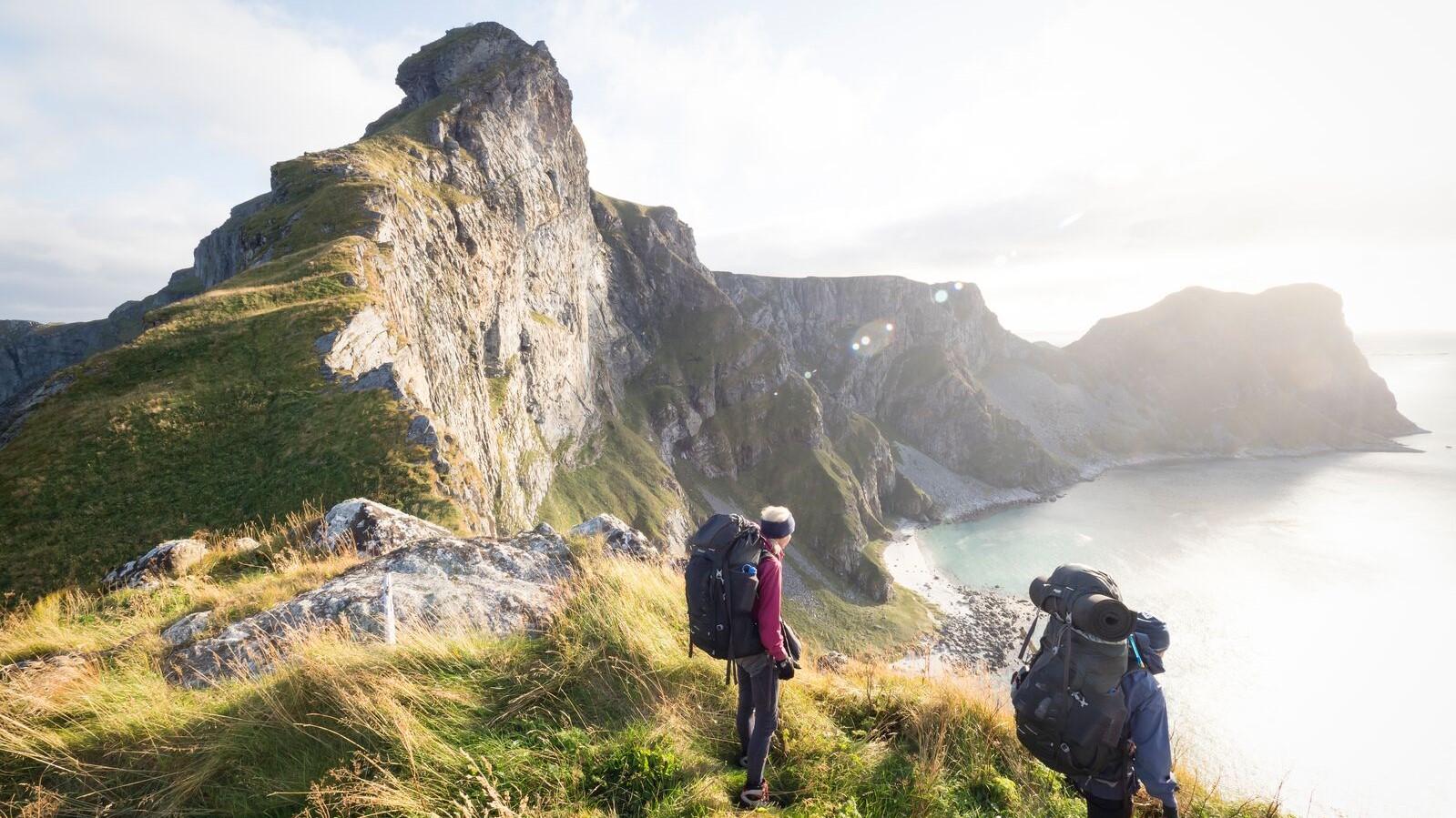 Two people hiking on the mountain of Værøy island in Lofoten in Northern Norway