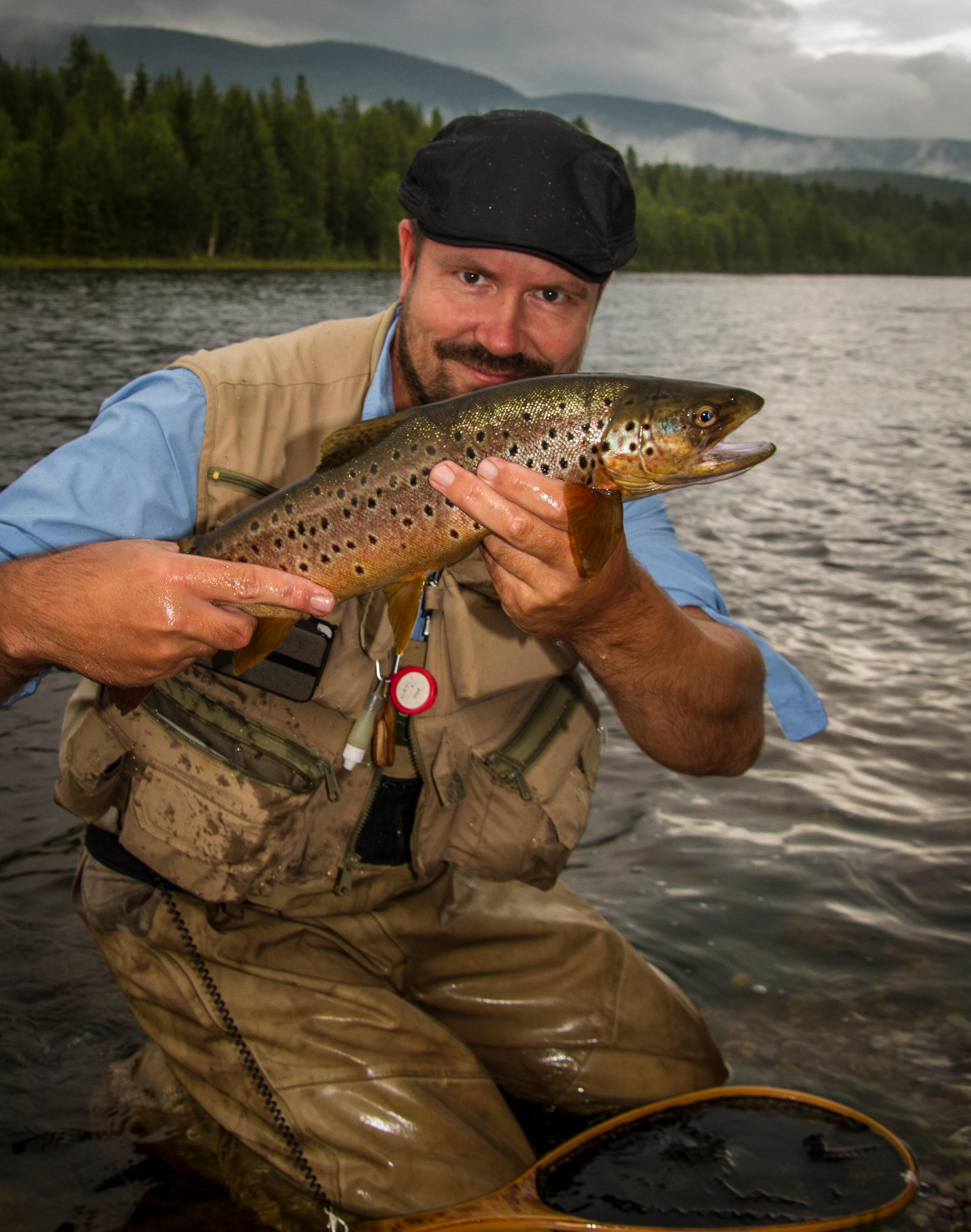 Teacher in fly fishing, Tore Litlere Rydgren in a river holding a fish