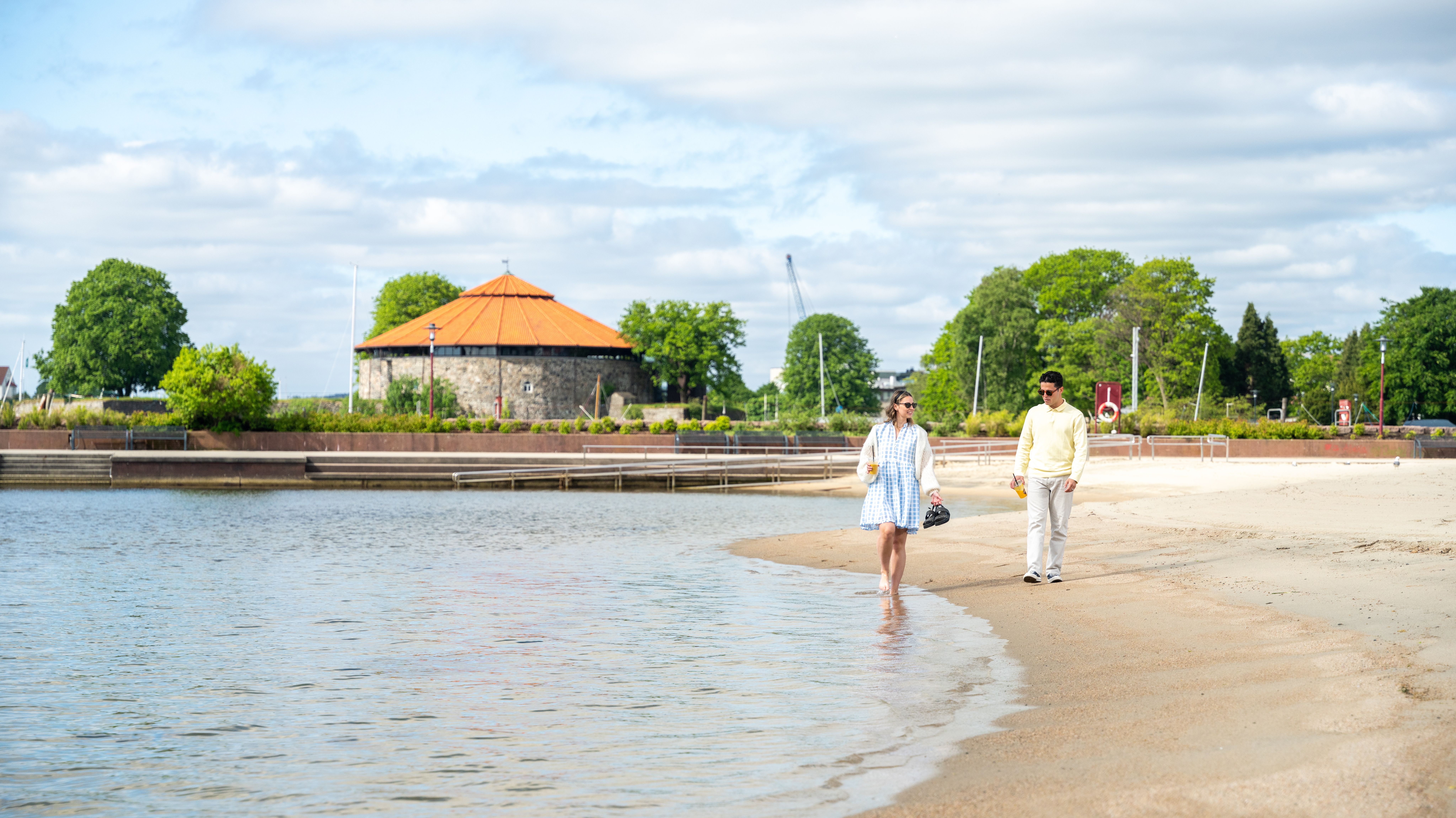Two friends walking on the Bystranda beach in Kristiansand, Southern Norway