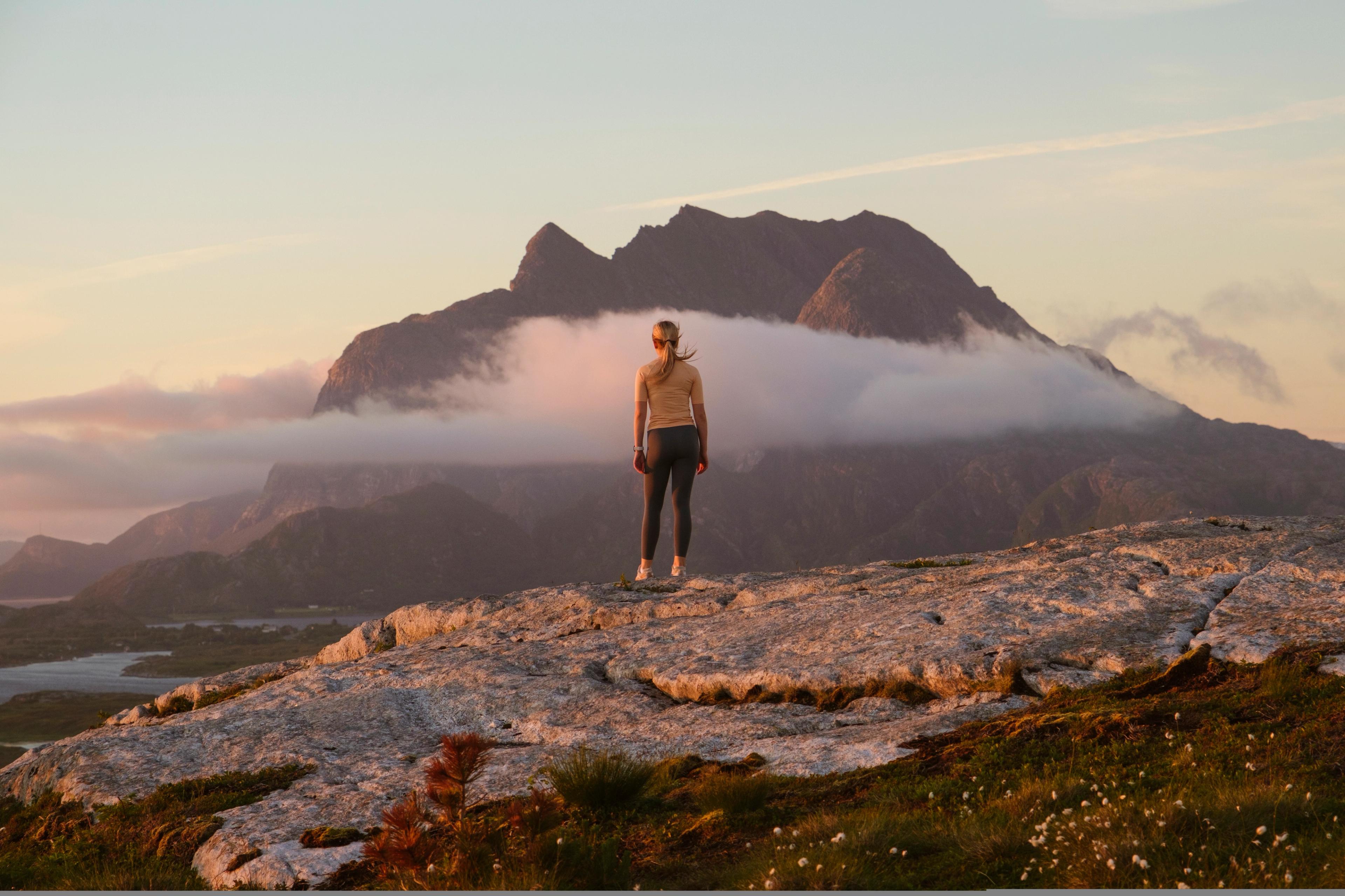 A woman going on a midnight hike to Øksningan, Helgeland, Norway.