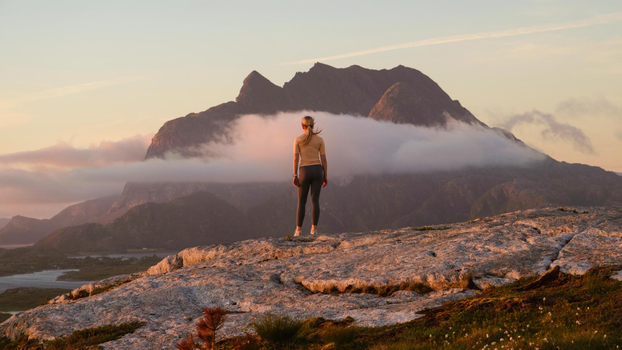 A woman going on a midnight hike to Øksningan, Helgeland, Norway.