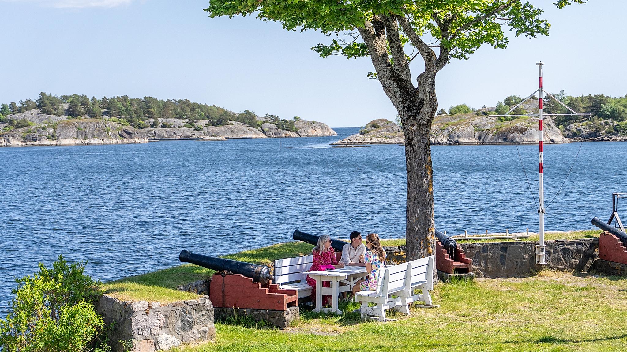 Three people enjoying the view at Kastellet in Risør, Southern Norway