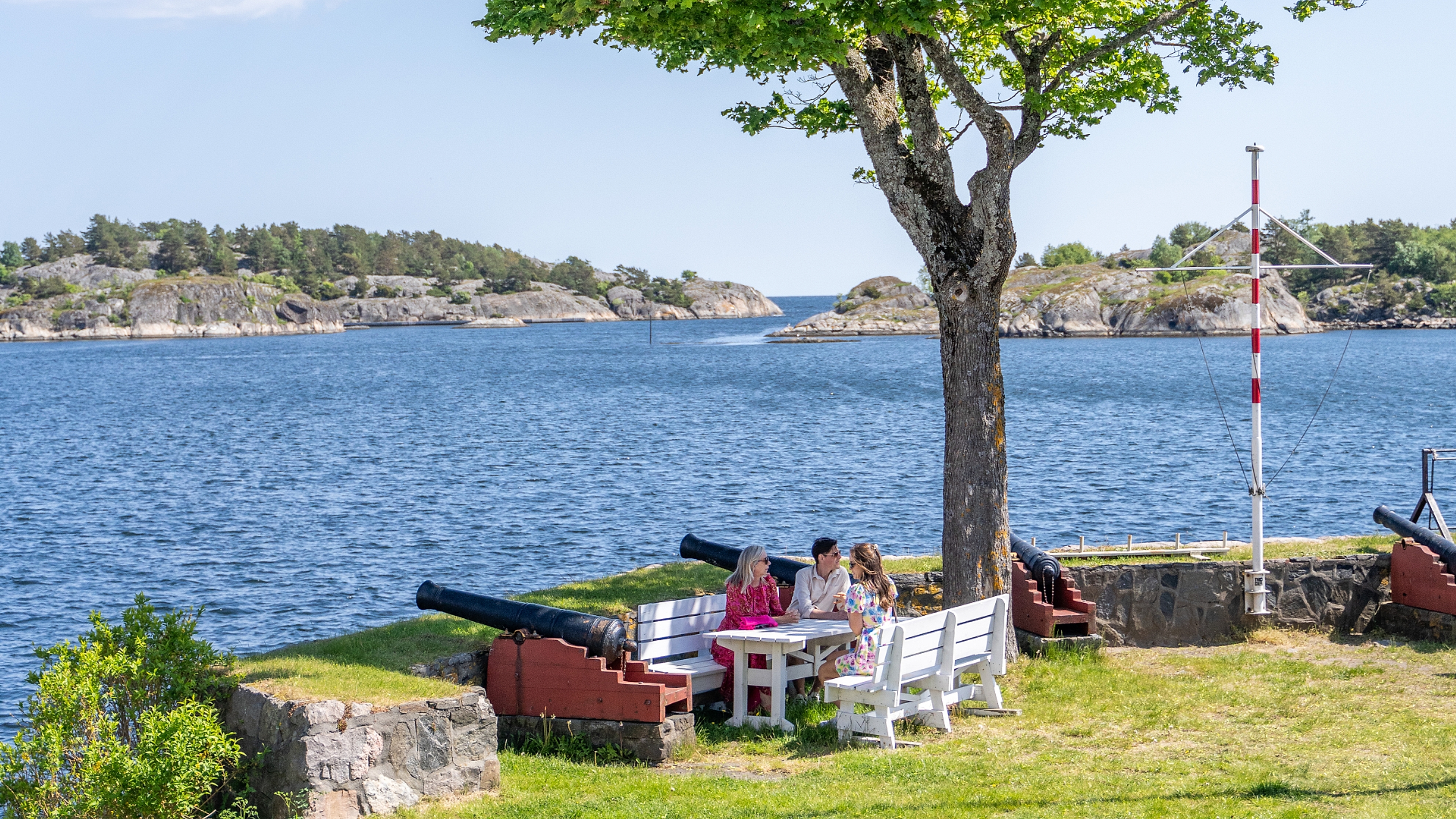 Three people enjoying the view at Kastellet in Risør, Southern Norway