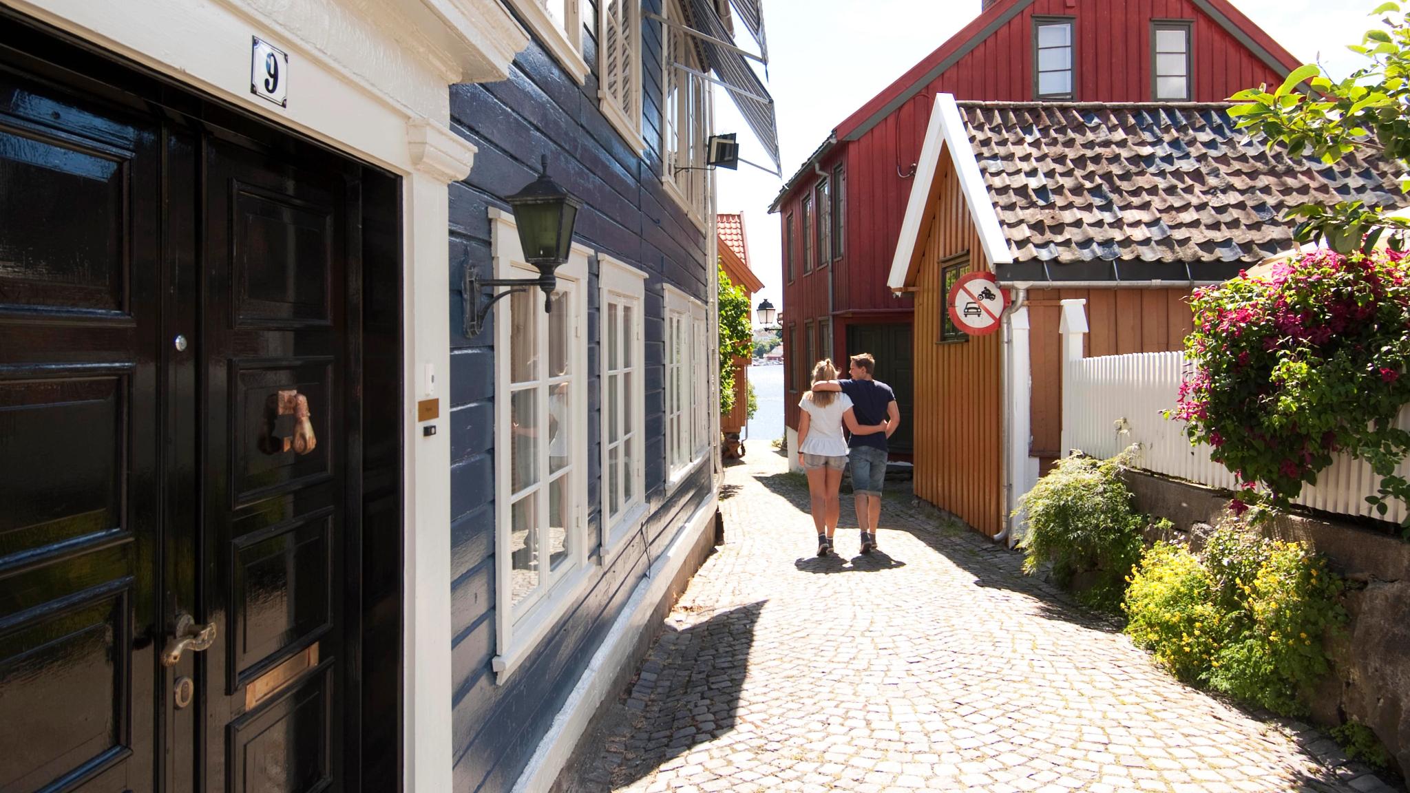 A couple wandering down a cobblestone street in Arendal, Southern Norway.
