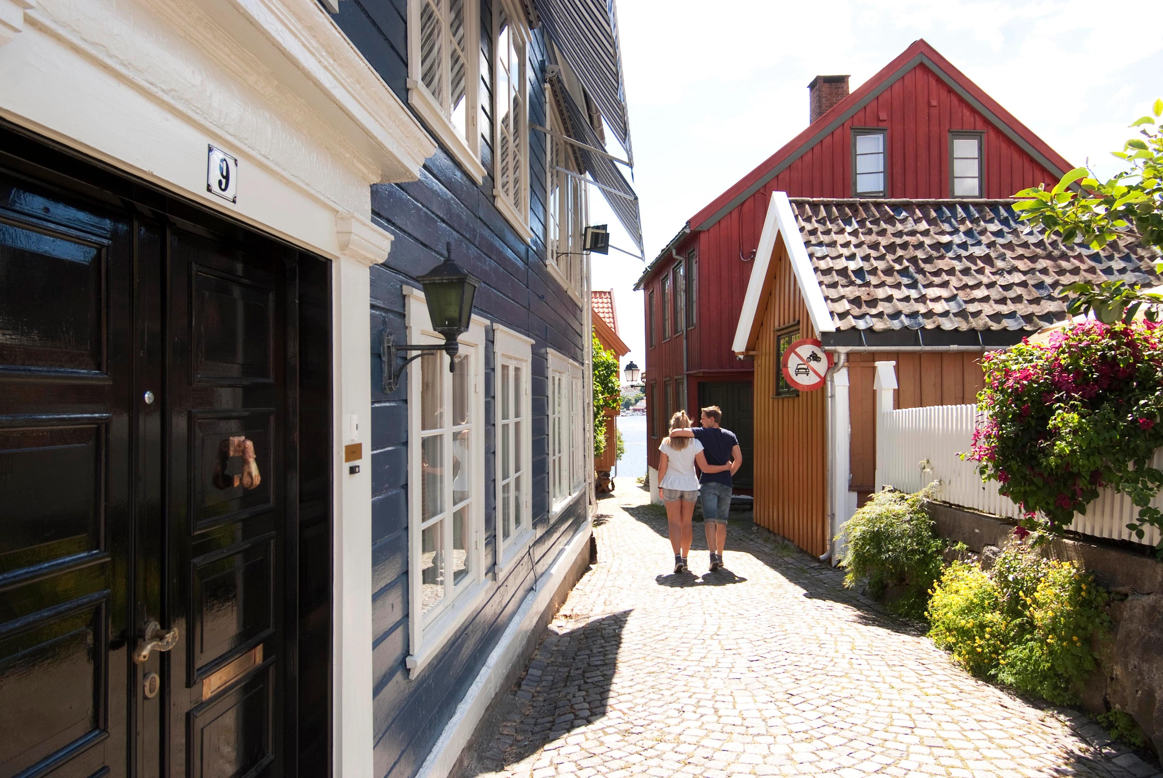 A couple wandering down a cobblestone street in Arendal, Southern Norway.