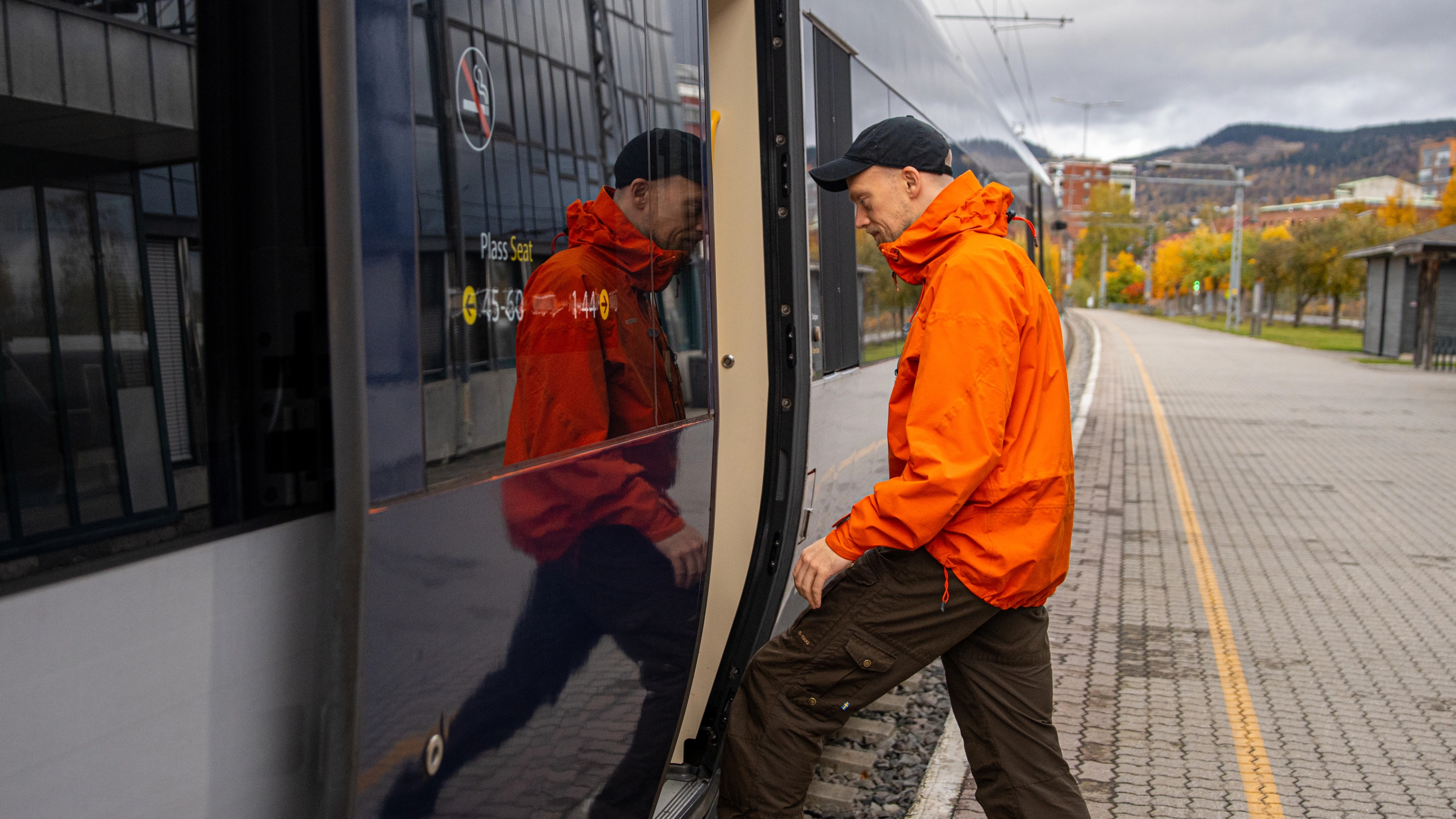 A man getting on board on the Dovre Railway train.