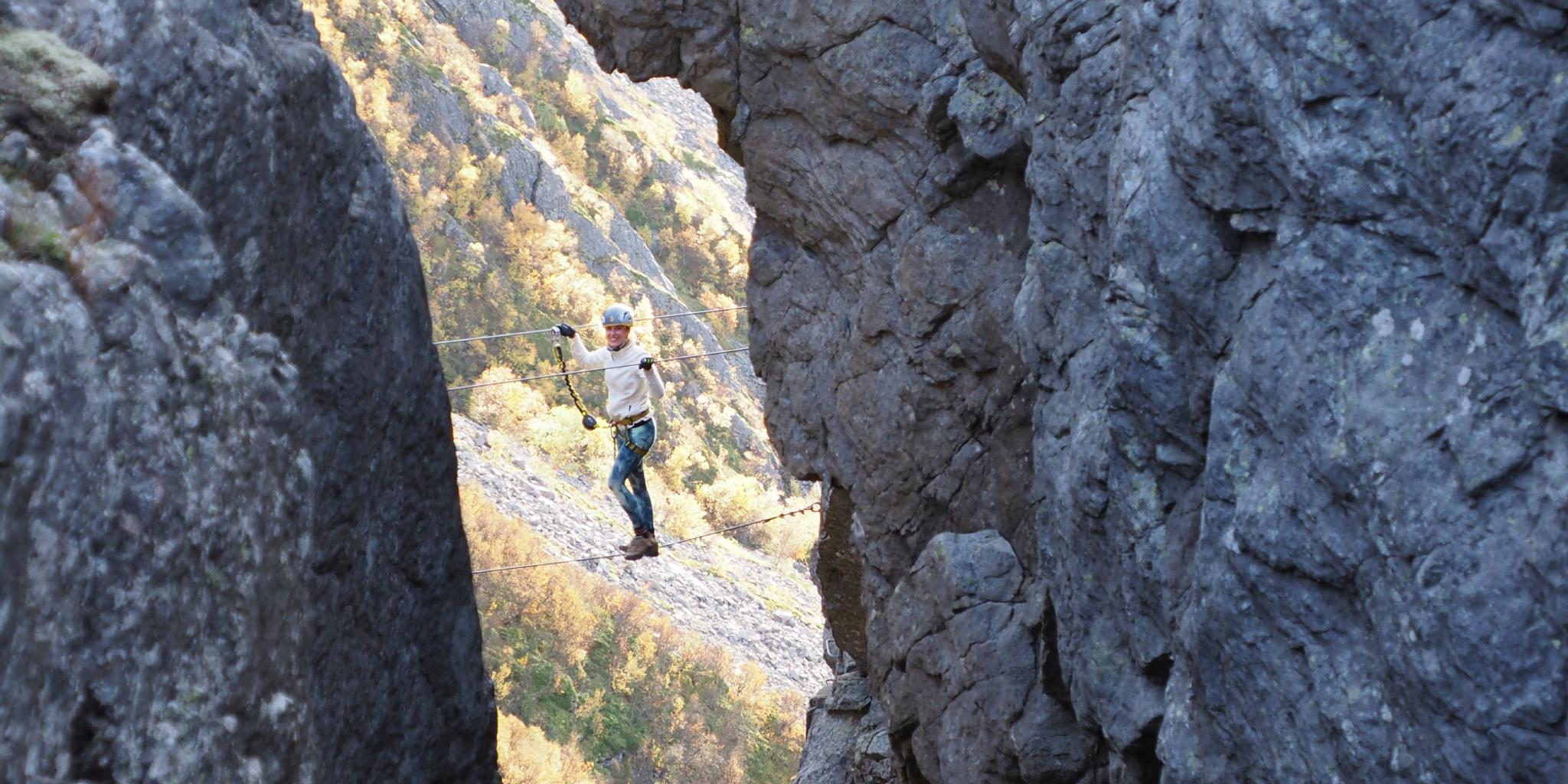 Woman climbing via ferrata Ravnfloget
