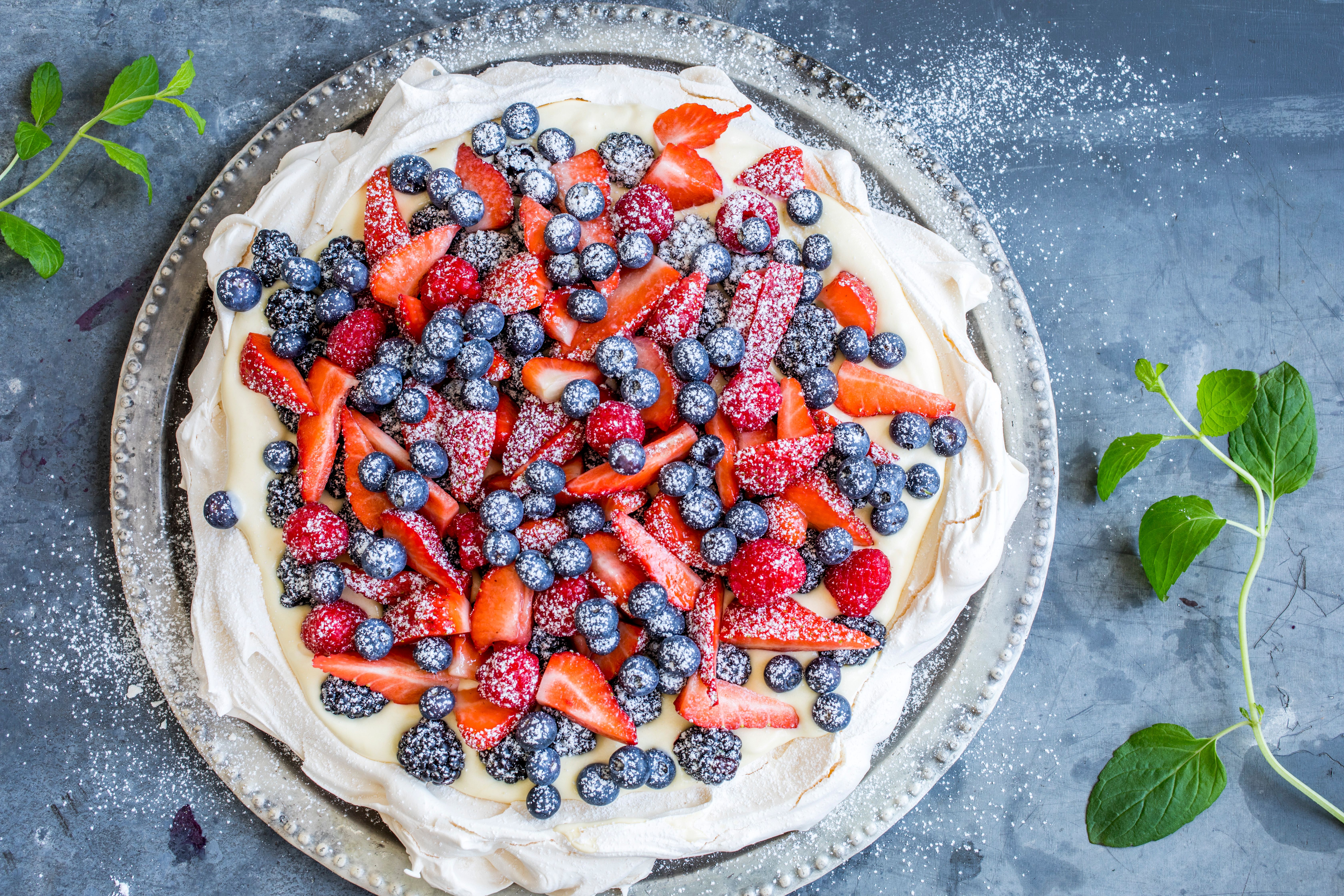 A pavlova decorated with fresh berries