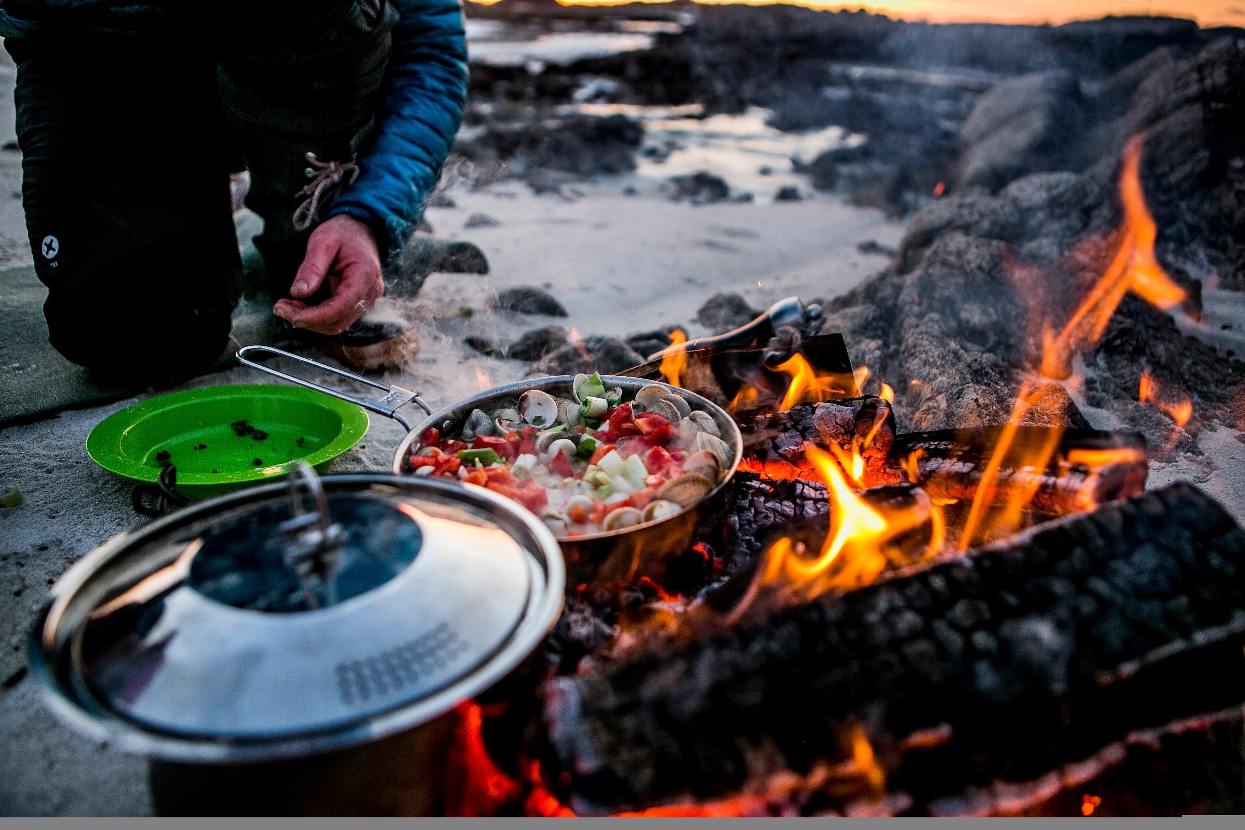 En dame lager mat på stranden i Steigen i Nordland, Nord-Norge