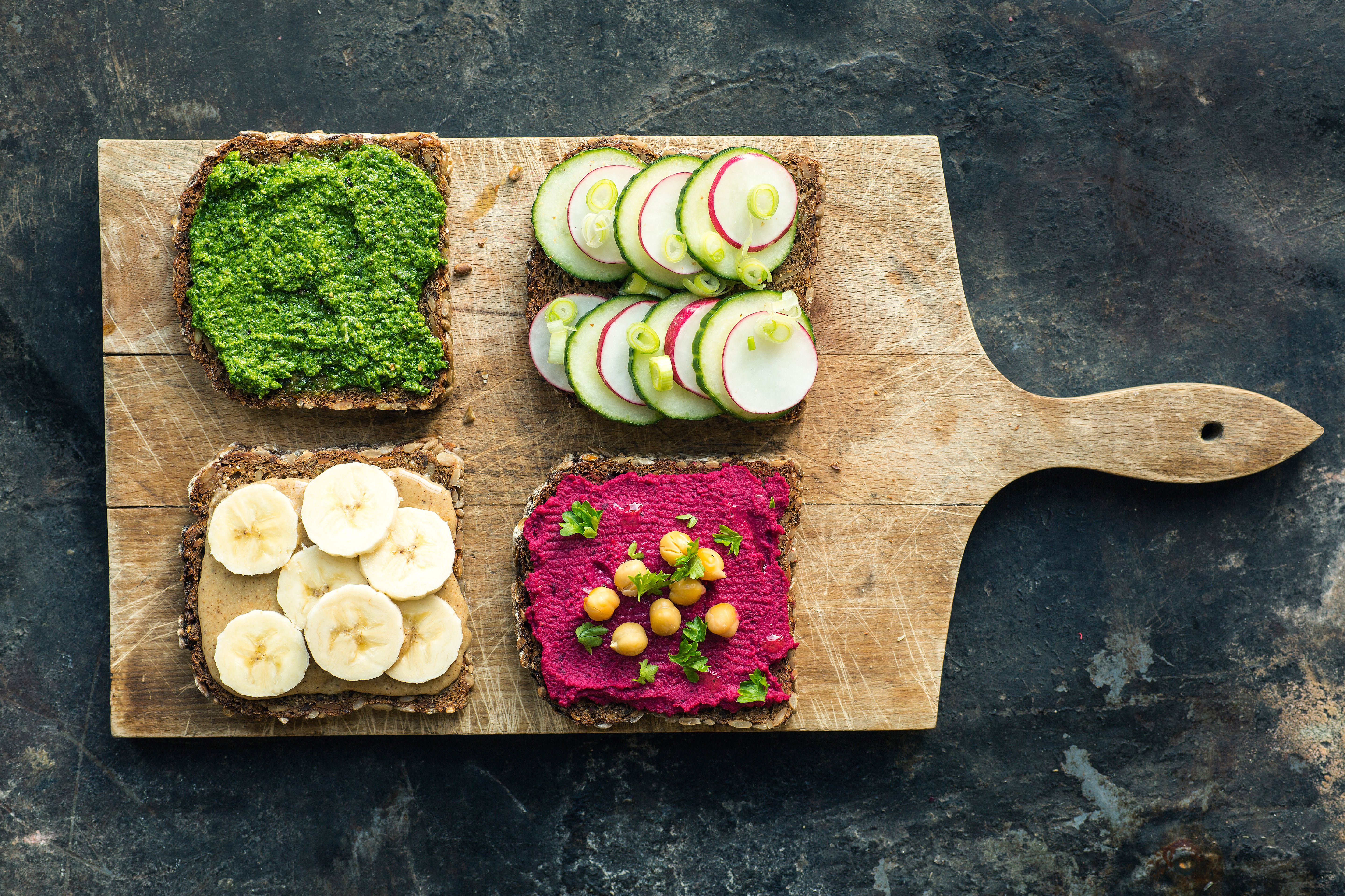 Slices of bread with various spreads and toppings served on a platter