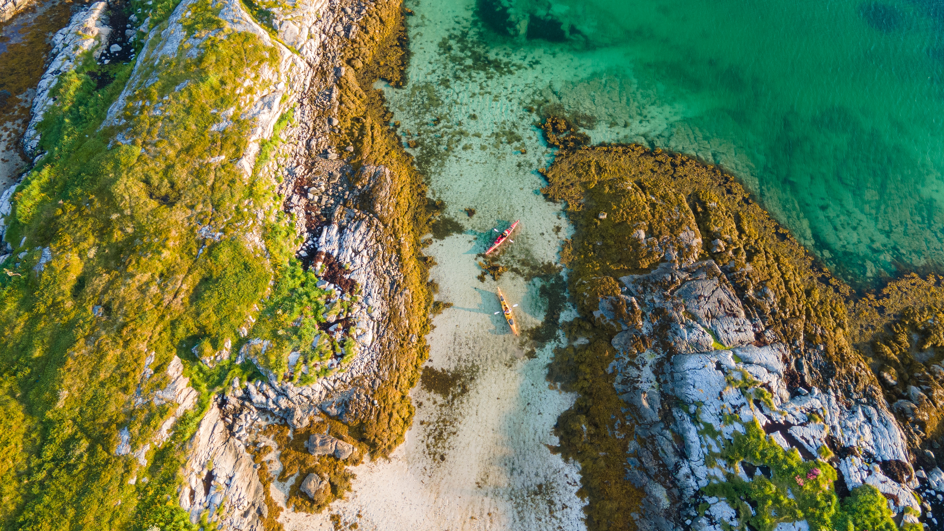 Two people kayaking in the evening sun in the archipelago in the Herøy Islands, Helgeland, Norway.