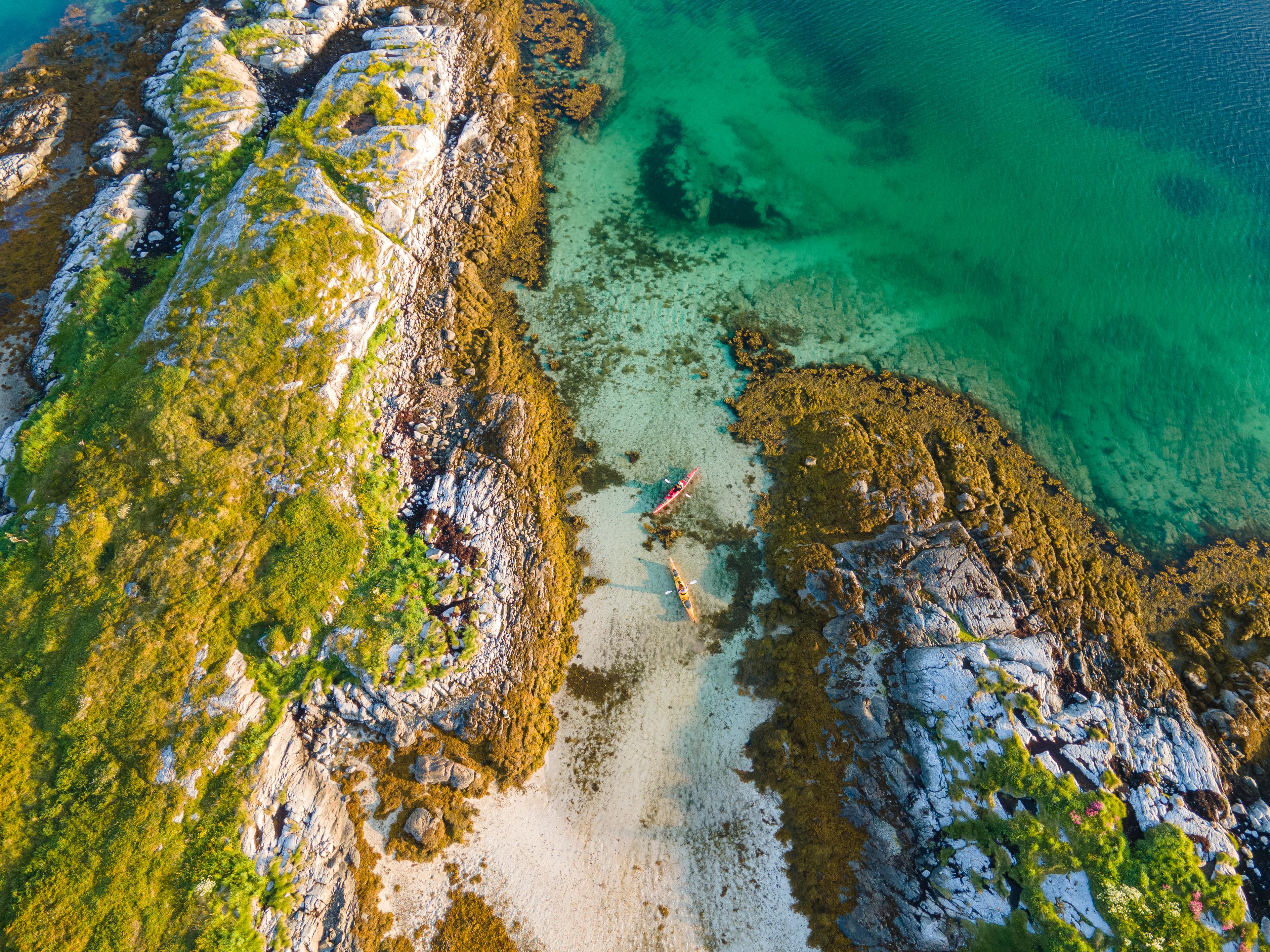 Two people kayaking in the evening sun in the archipelago in the Herøy Islands, Helgeland, Norway.