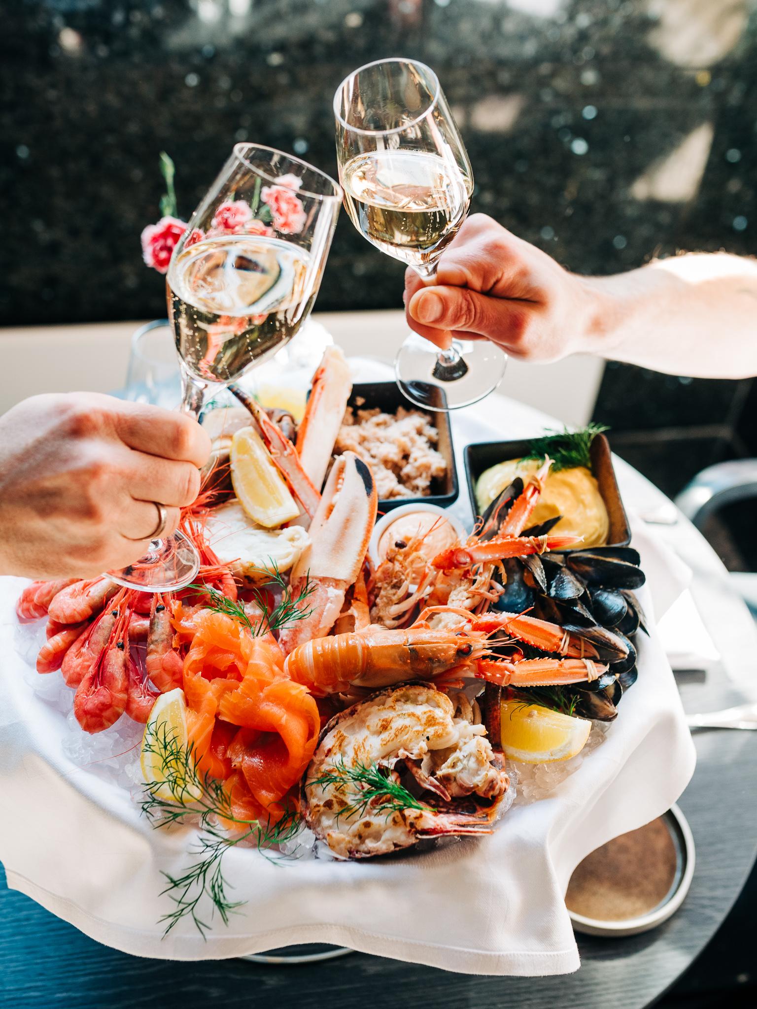 A plate of seafood and two glasses of champaign at restaurant Opus XVI in Bergen in Fjord Norway