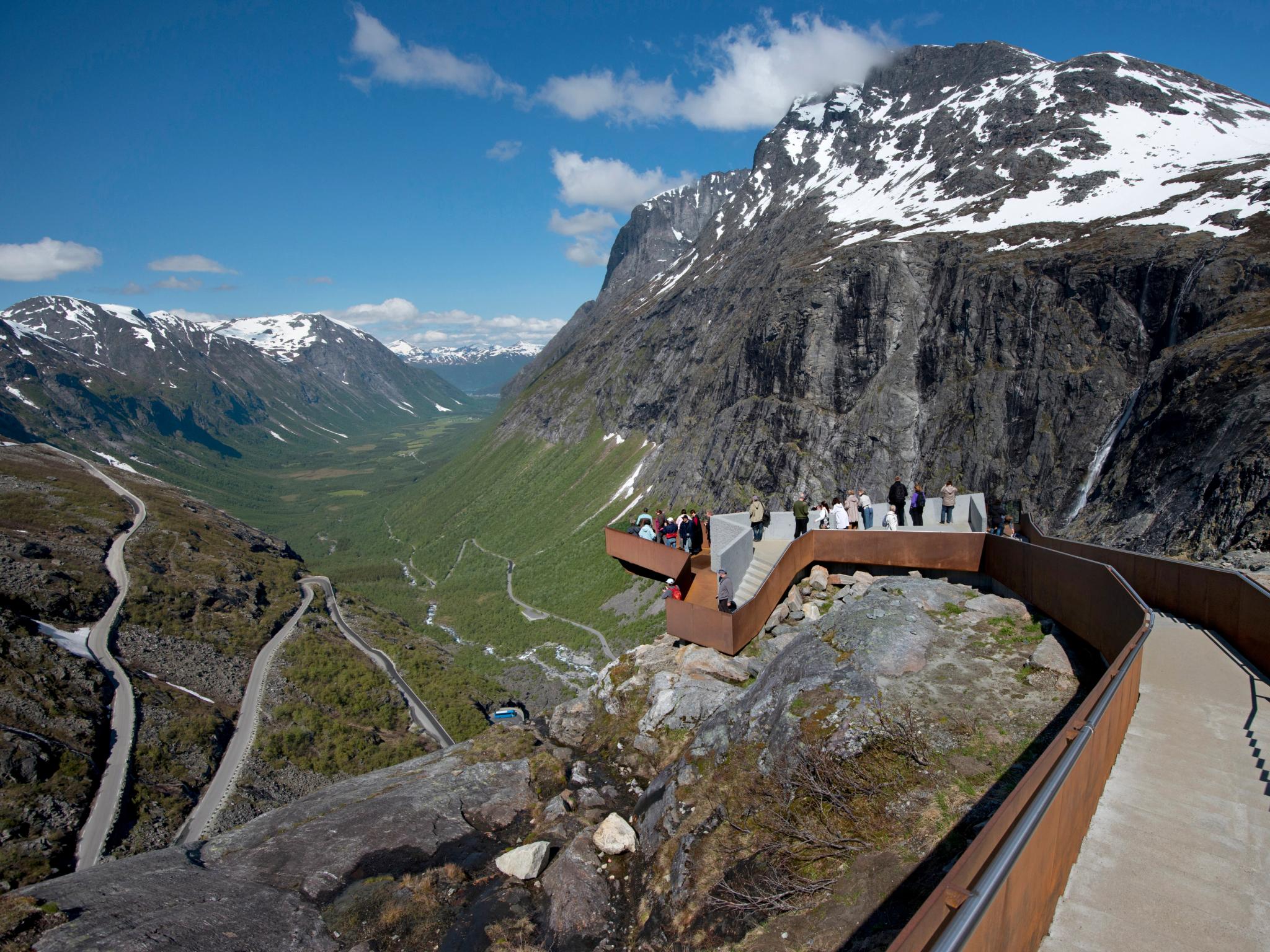 People admiring the view of the Norwegian Scenic Route Trollstigen in Fjord Norway from Trollstigen viewpoint