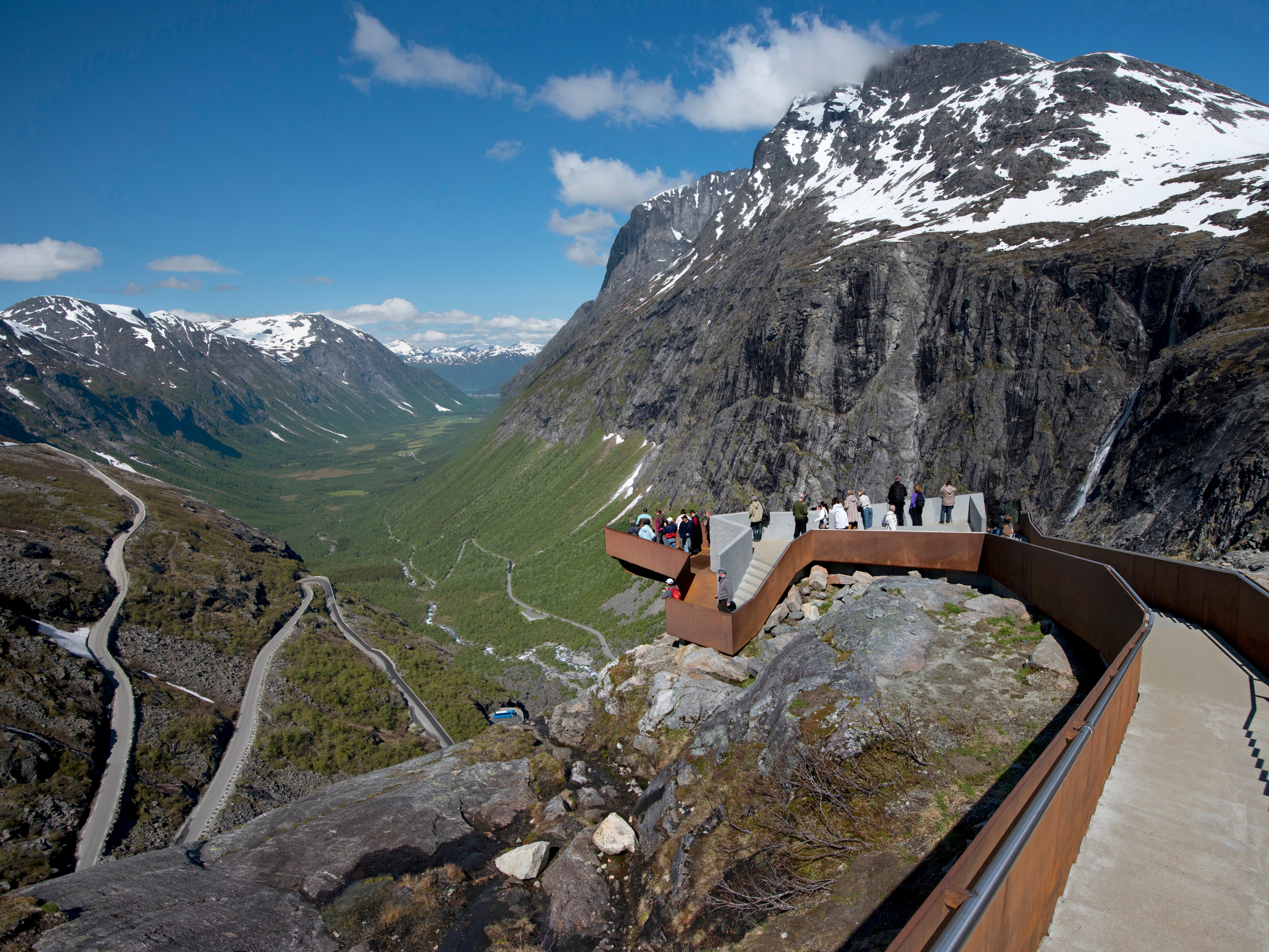 People admiring the view of the Norwegian Scenic Route Trollstigen in Fjord Norway from Trollstigen viewpoint