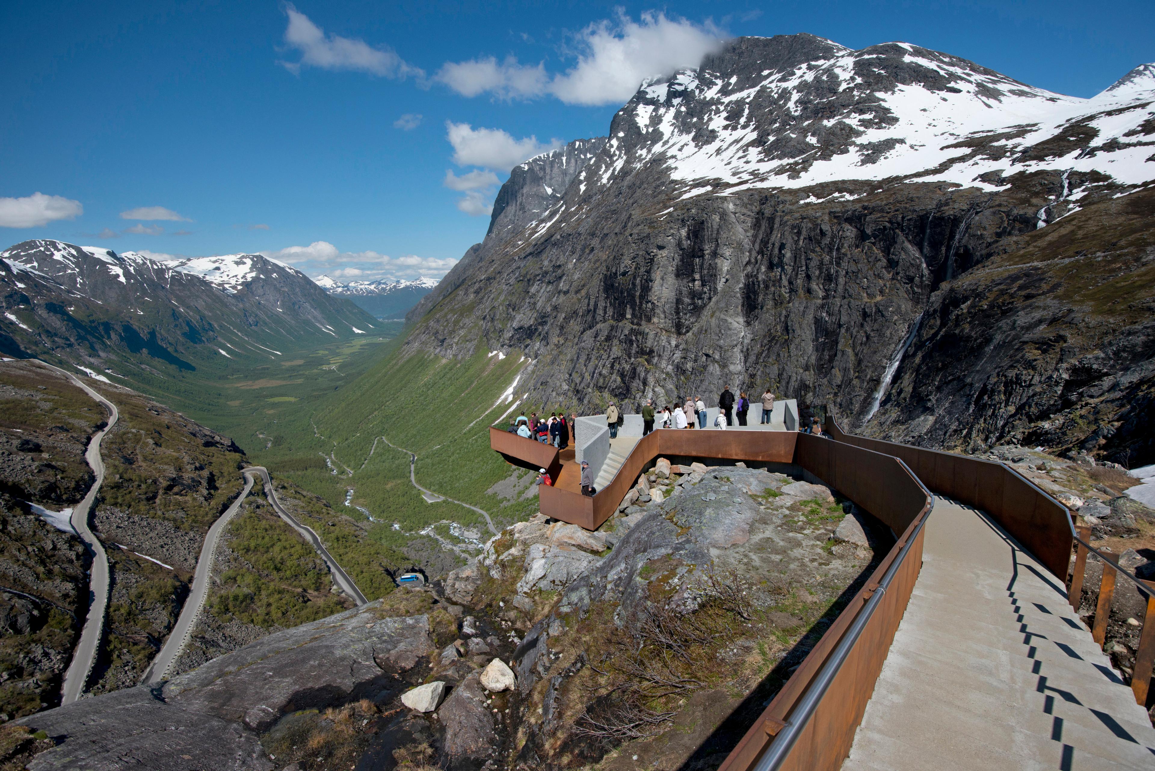 People admiring the view of the Norwegian Scenic Route Trollstigen in Fjord Norway from Trollstigen viewpoint