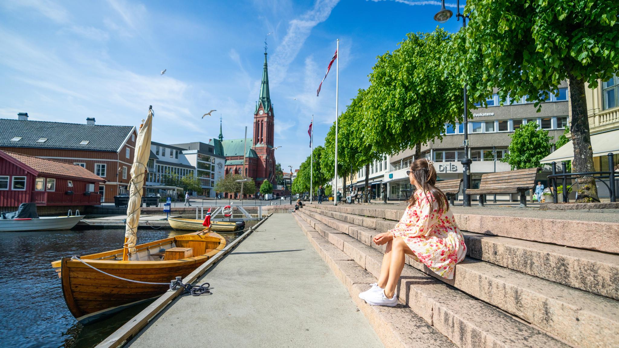 Girl sitting in some stairs by the Pollen harbour in Arendal, Southern Norway