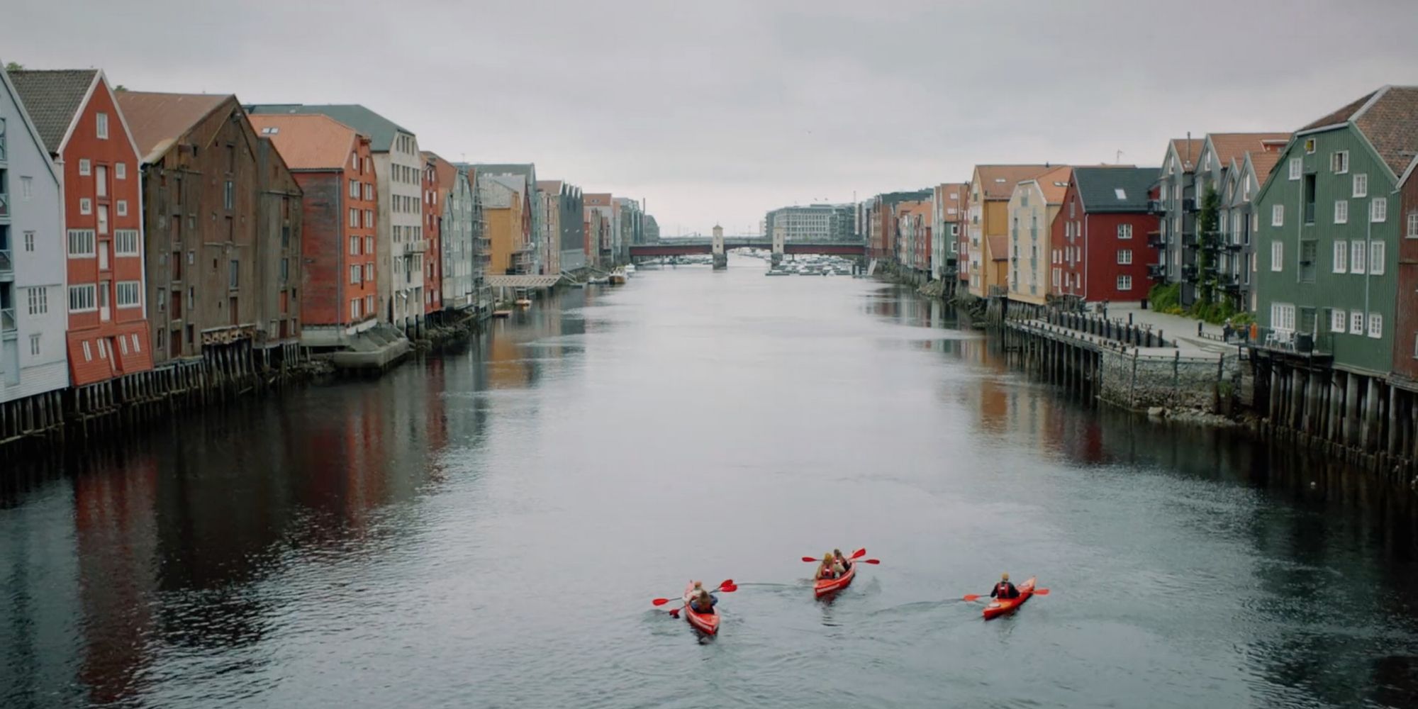 Tre personer padler kajakk i Nidelva i Trondheim