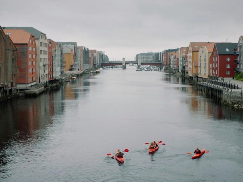 Tre personer padler kajakk i Nidelva i Trondheim